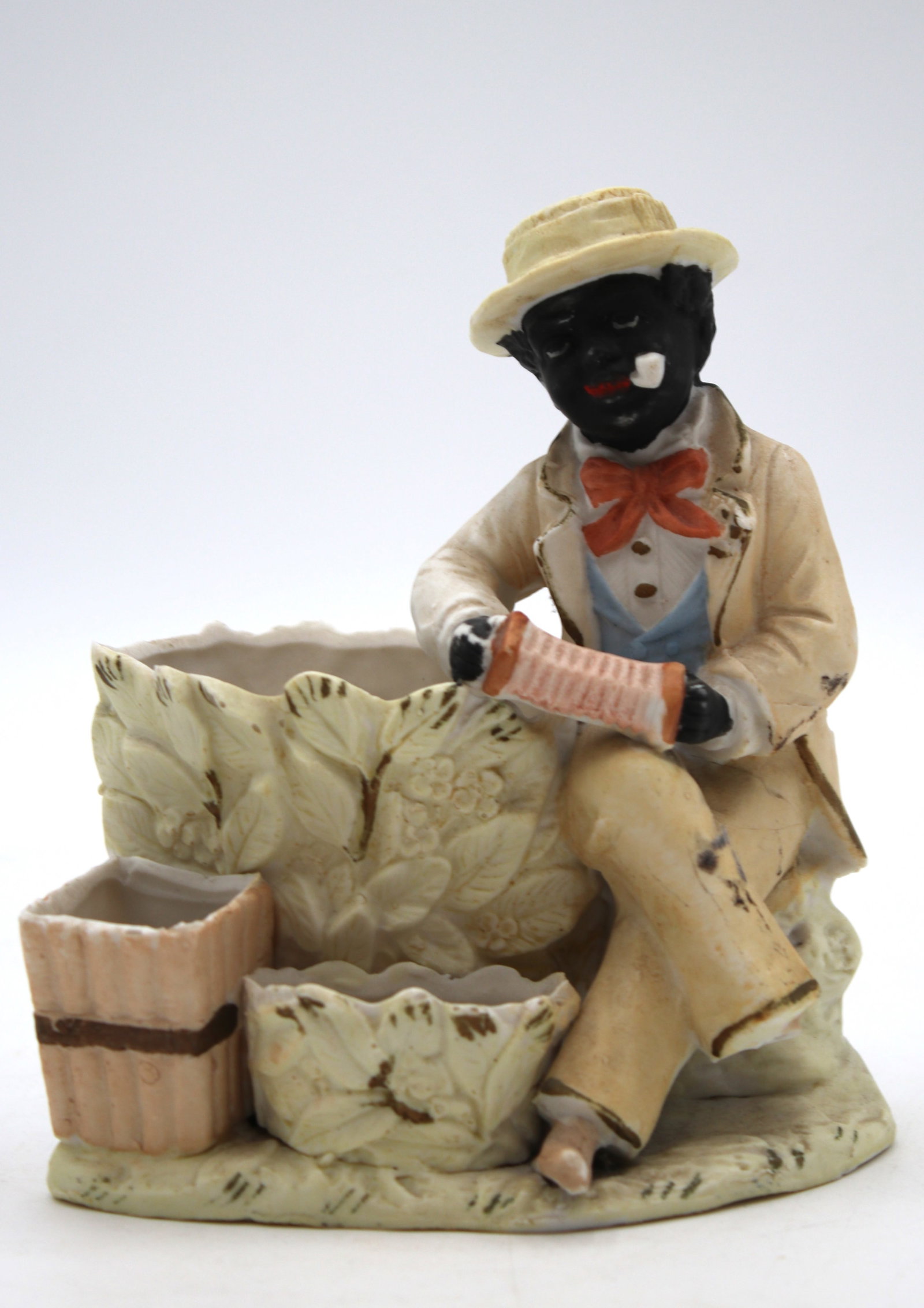 Yellow Vintage C. 1930 Black Americana Man Sitting With Accordion Cigarette, Match Holder And: Yellow Vintage C. 1930 Black Americana Man Sitting With Accordion Cigarette, Match Holder And Ashtray Figurine. This vintage c. 1930 Black Americana figurine depicts a charming scene of a seated man p
