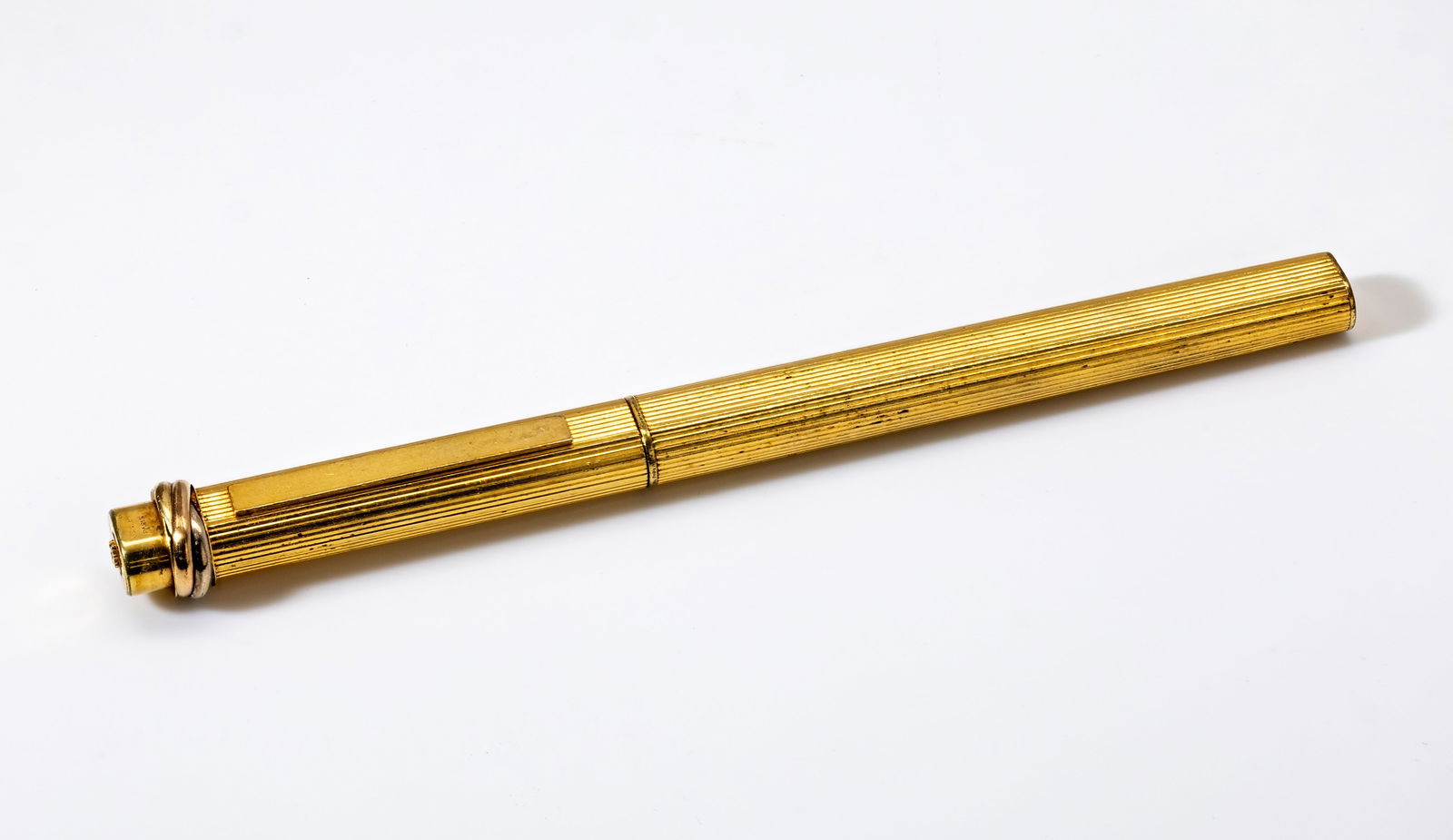 CARTIER TRINITY STRIPE CAP BALLPOINT PEN: Description:Cartier Trinity Stripe Cap Ballpoint Pen is Plated in 24k Gold and has French Hallmarks indicating this is a plated piece PLAQUE OR G. Engravings number is 116009 Brand:Cartier Material:Go