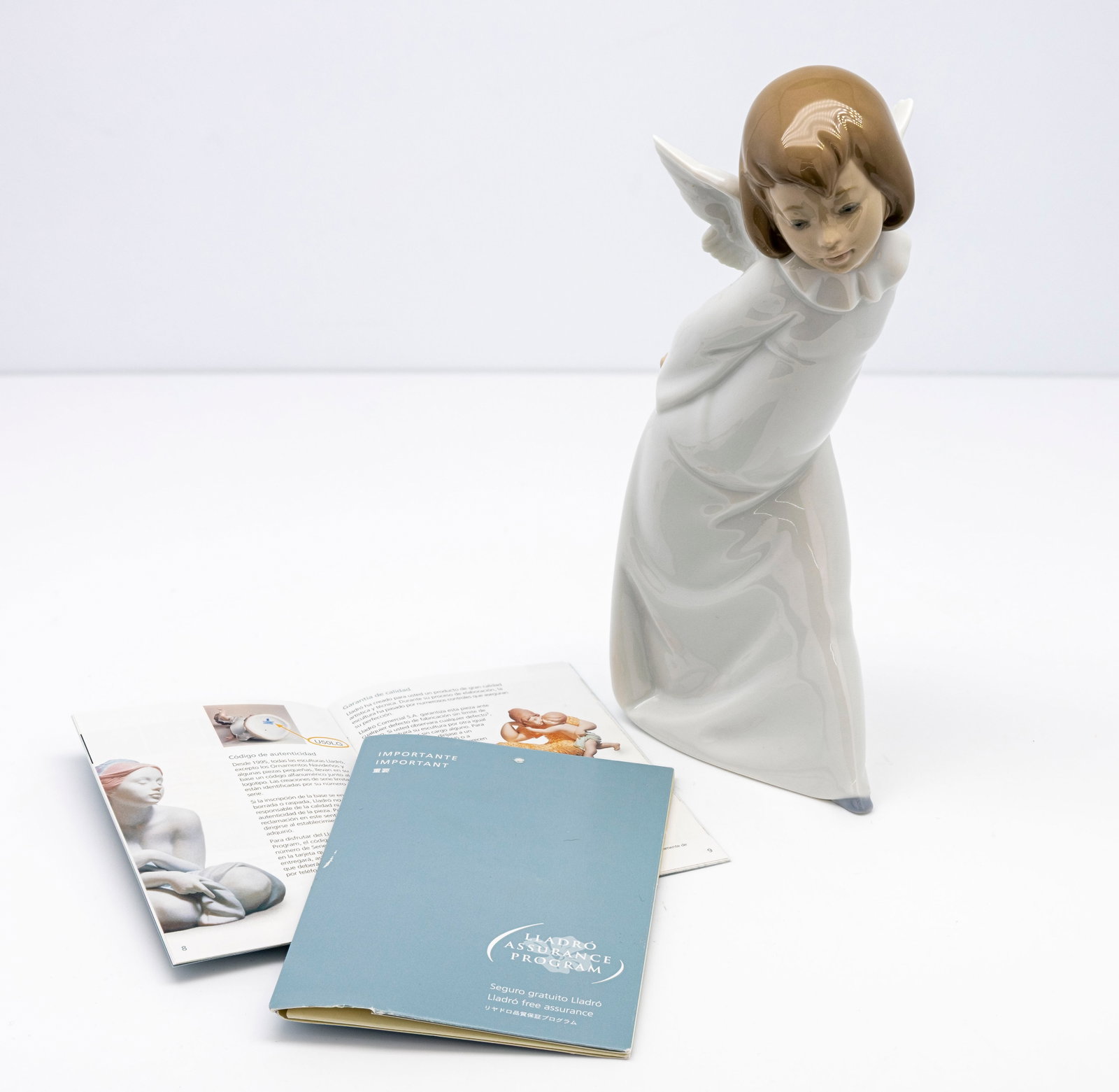 Lladro "Curious Angel" 1977: Title: "Curious Angel" by Lladro. Artist: Created by Salvador Debon. Description: Depicts a glossy, white porcelain angel holding a lanter behind its back appearing to look upward with
