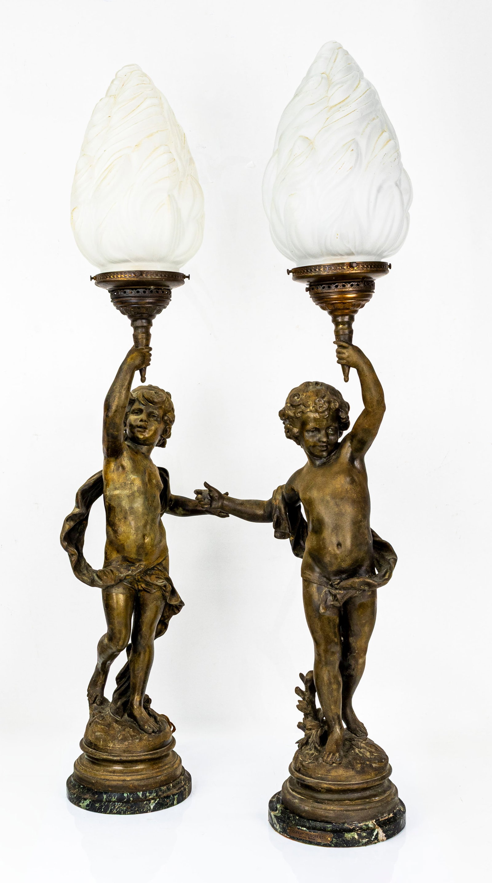 Pair of French Figural Torchere lamps with Frosted Flame Shades: Title: Pair of French Figural Torchere lamps with Frosted Flame Shades Description: A charming pair of antique figural lamps, each modeled as a cherubic ch