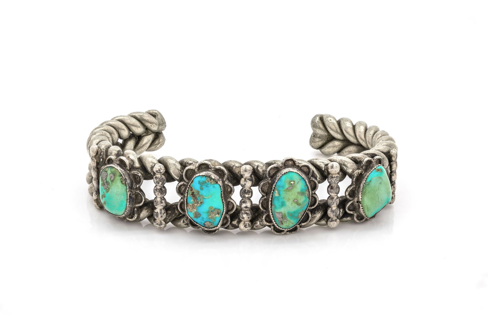 Navajo Twisted Silver Cuff Bracelet with Turquoise 4 stones: Title: Navajo Twisted Silver Cuff Bracelet with TurquoiseOrigin: Native American, NavajoMaterial: Sterling silver with natural turquoise cabochonsSize: 6 1/2Weight: 57.71 gDescription: Handcrafted