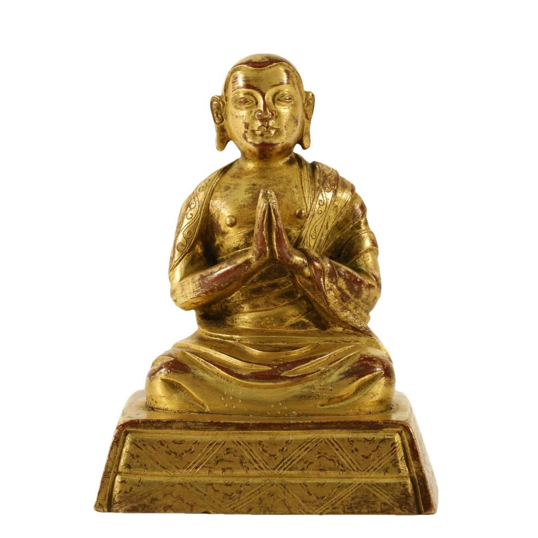 A Gilt-Bronze Figure Of Brog.Mi: A Gilt-Bronze Figure Of Brog.Mi. Seated on a base with a peaceful expression, body rendered clad in a robe, the voluminous drapery elegantly cascading in folds, putting two palms together devoutly. 18