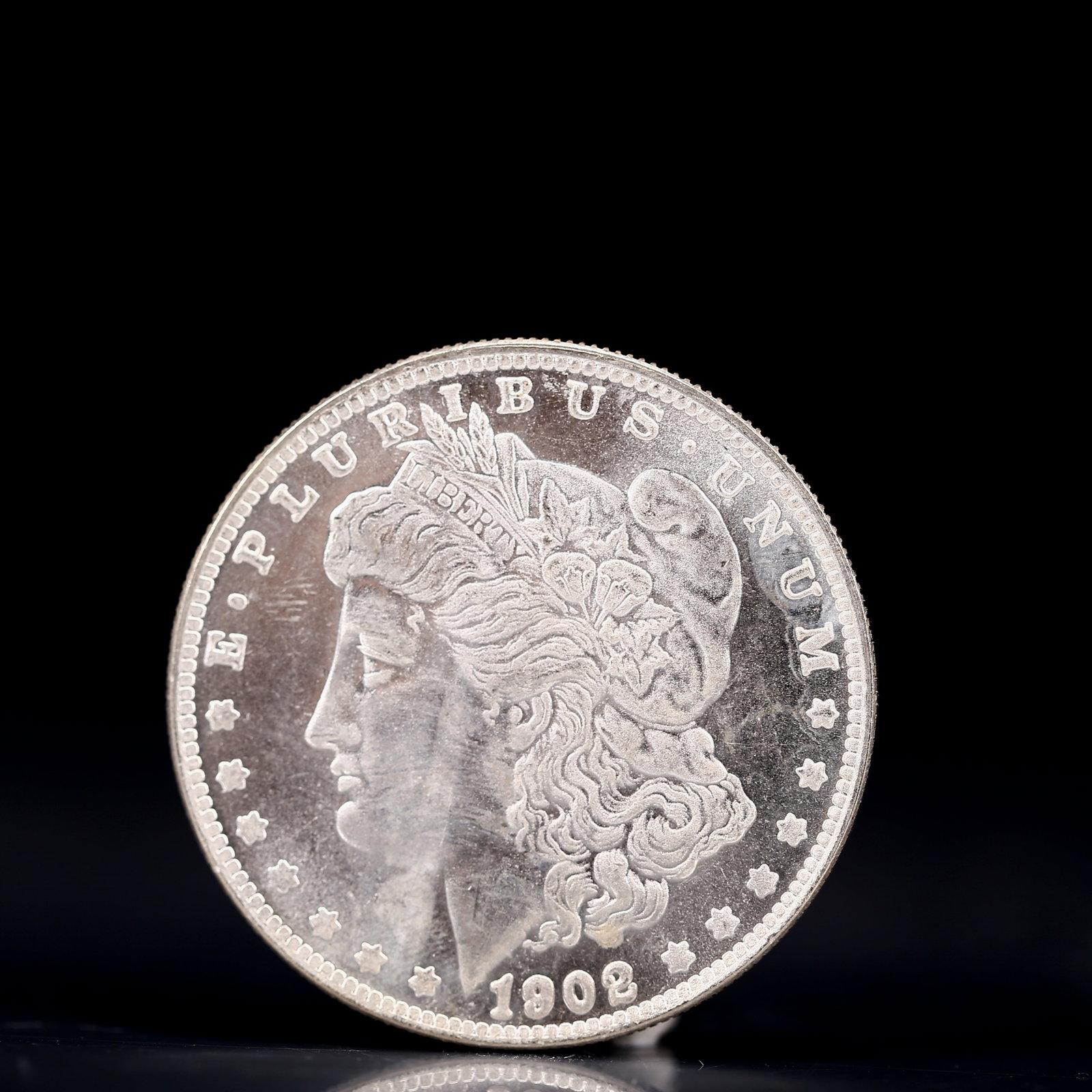 USA Morgan Dollar 1902 Coin: Obv: profile bust with date below and E PLURIBUS UNUM legend and stars around. Rev: eagle with In God we trust above within wreath with UNITED STATES OF AMERICA ONE DOLLAR legend. IN GOD WE TRUST / LI