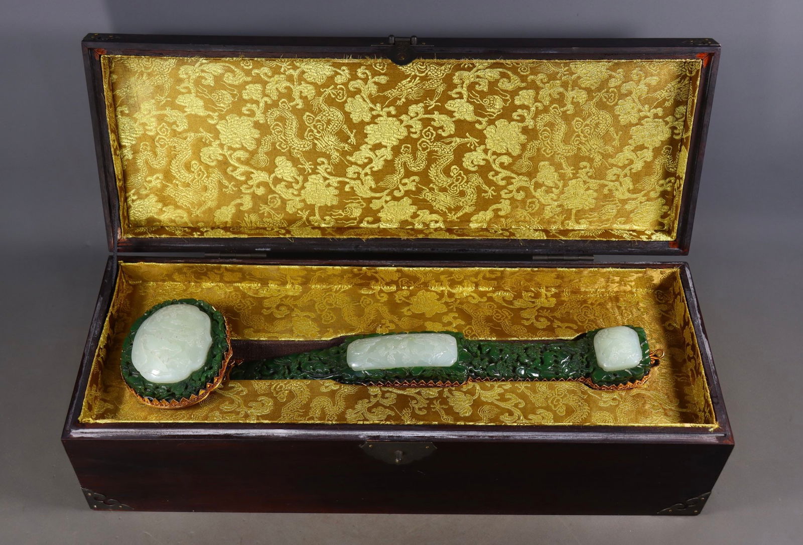 An Exquisite Jasper Inlaid White Jade Cover with Gold Landscape and Figure Pattern Ruyi: An Exquisite Jasper Inlaid White Jade Cover with Gold Landscape and Figure Pattern Ruyi Qing Dynasty, China Size:3.1inx15.9inx3.7in Weight:1245g碧玉镶嵌白玉包