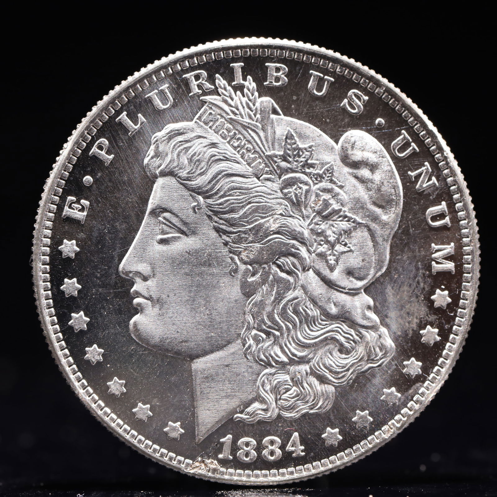 USA Morgan Dollar 1884 Coin: Obv: profile bust with date below and E PLURIBUS UNUM legend and stars around. Rev: eagle with In God we trust above within wreath with UNITED STATES OF AMERICA ONE DOLLAR legend. IN GOD WE TRUST / LI