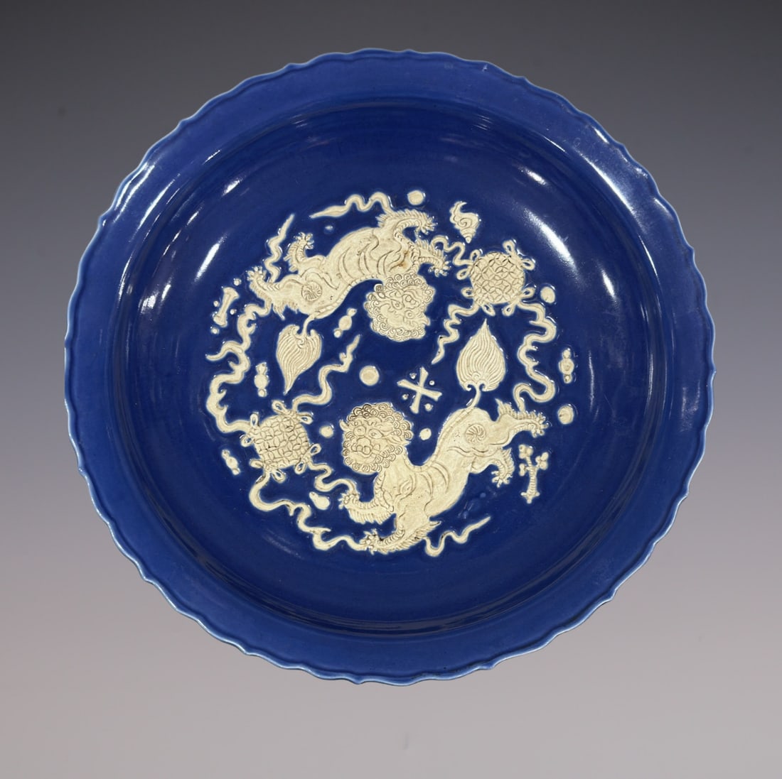An Exquisite Ji Blue Glazed Lion Pattern Plate: An Exquisite Ji Blue Glazed Lion Pattern Plate Yuan Dynasty, China Size:3inx17.5in霁蓝釉雕刻狮子滚绣球纹大盘
