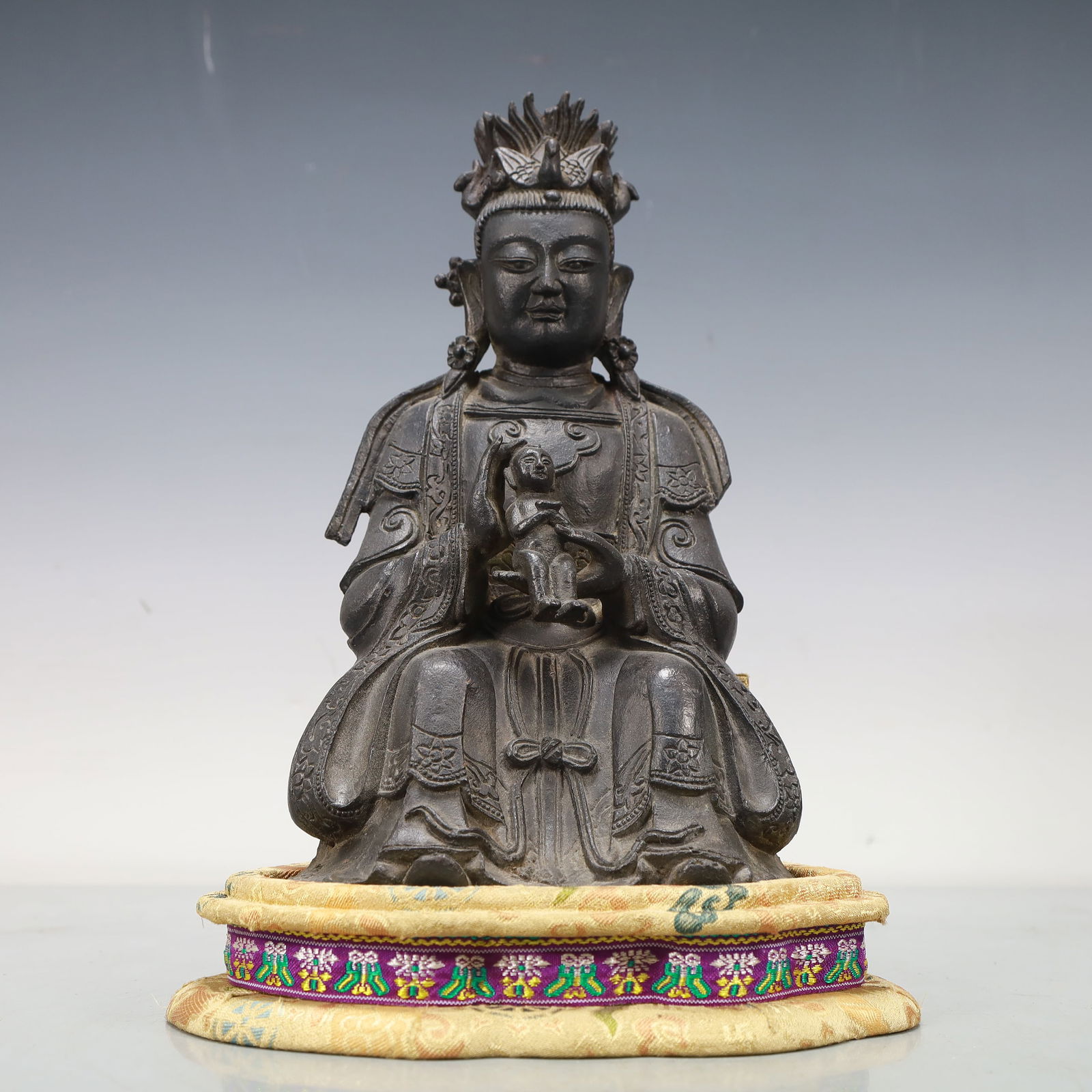 An Excellent Bronze Figure Of Guanyin And A Boy: An Excellent Bronze Figure Of Guanyin And A Boy. Seated with a benevolent expression,body rendered clad in long,flowing robes,the voluminous drapery elegantly cascading in folds. Chinese Ming