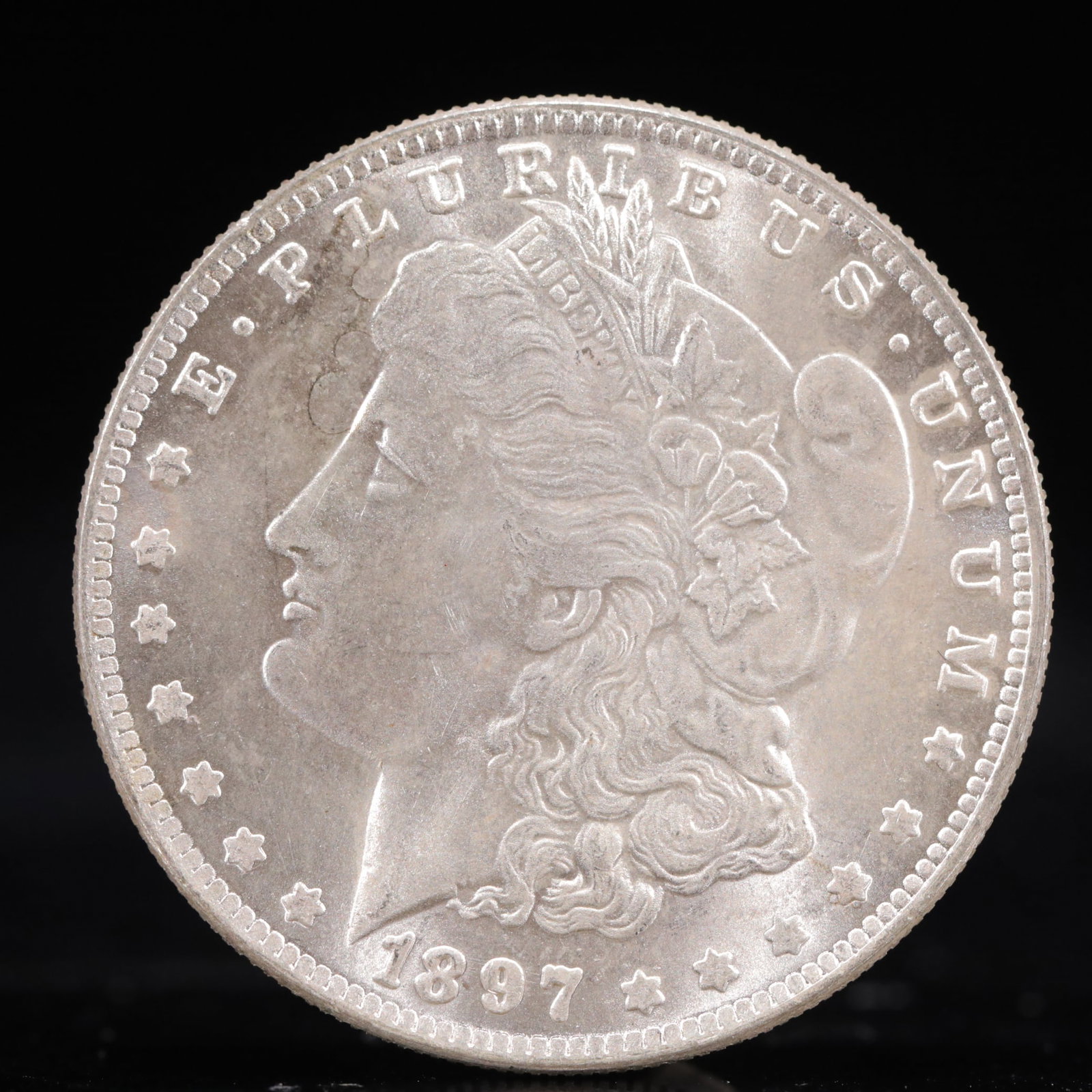 USA Morgan Dollar 1897 Coin: Obv: profile bust with date below and E PLURIBUS UNUM legend and stars around. Rev: eagle with In God we trust above within wreath with UNITED STATES OF AMERICA ONE DOLLAR legend. IN GOD WE TRUST / LI