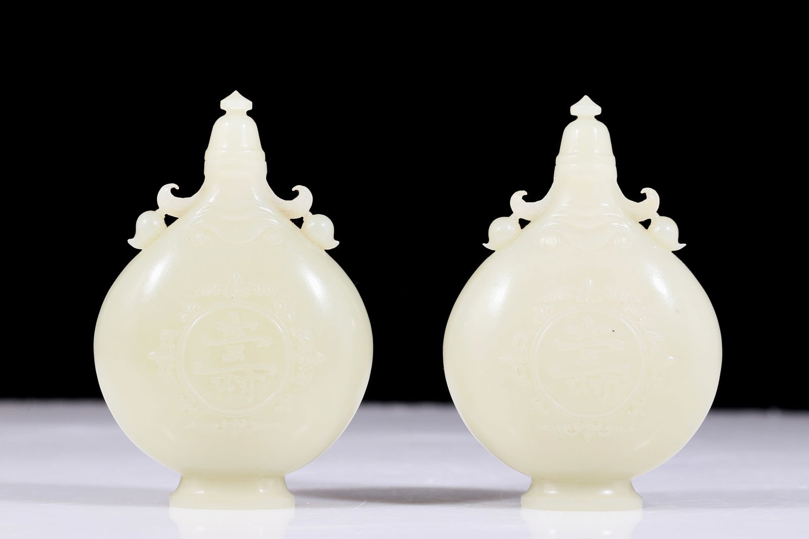 A pair of exquisite white jade amphora with floral patterns: pair of exquisite white jade flower-patterned amphora. The jade exhibits delicate, warm and lustrous qualities. The craftsmanship is flawless, the design is exquisite, and the carvings are exquisite,