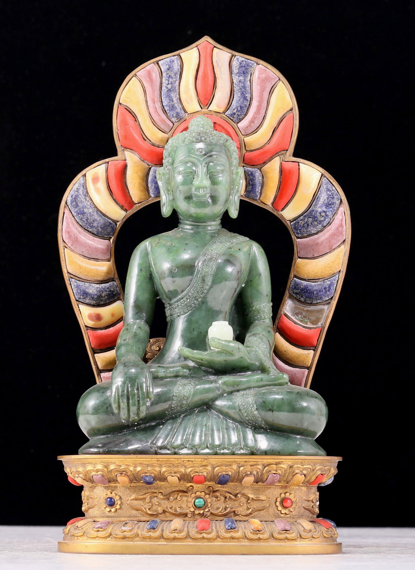 A solemn gilt bronze and gem-set jasper statue of Gautama Buddha: A solemn gilt copper inlaid with gemstones and a jasper statue of Sakyamuni. Qing Dynasty , China. jade showed the qualities of fineness, delicacy, warmth and luster. The craftsmanship is flawless,