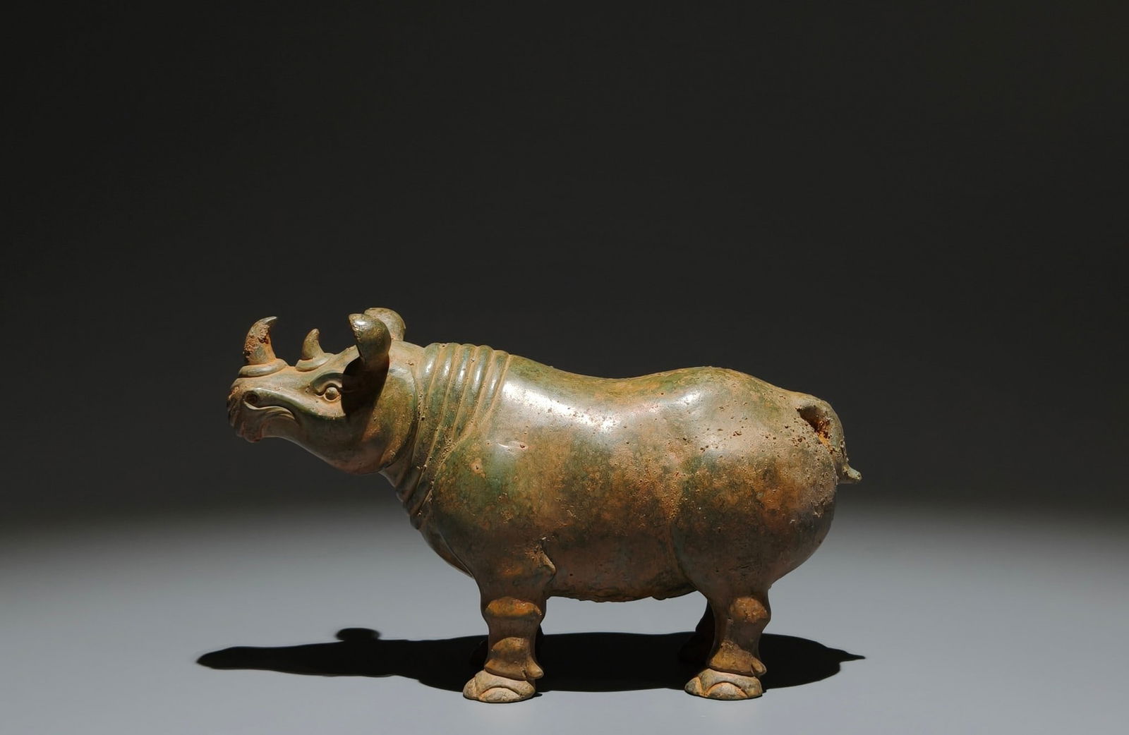 An Archaic Bronze Rhinoceros Ornament: An Archaic Bronze Rhinoceros Ornament,Han Dynasty, China,Size:4.3inx7.5inx2.4in 青铜犀牛摆件,中国汉代