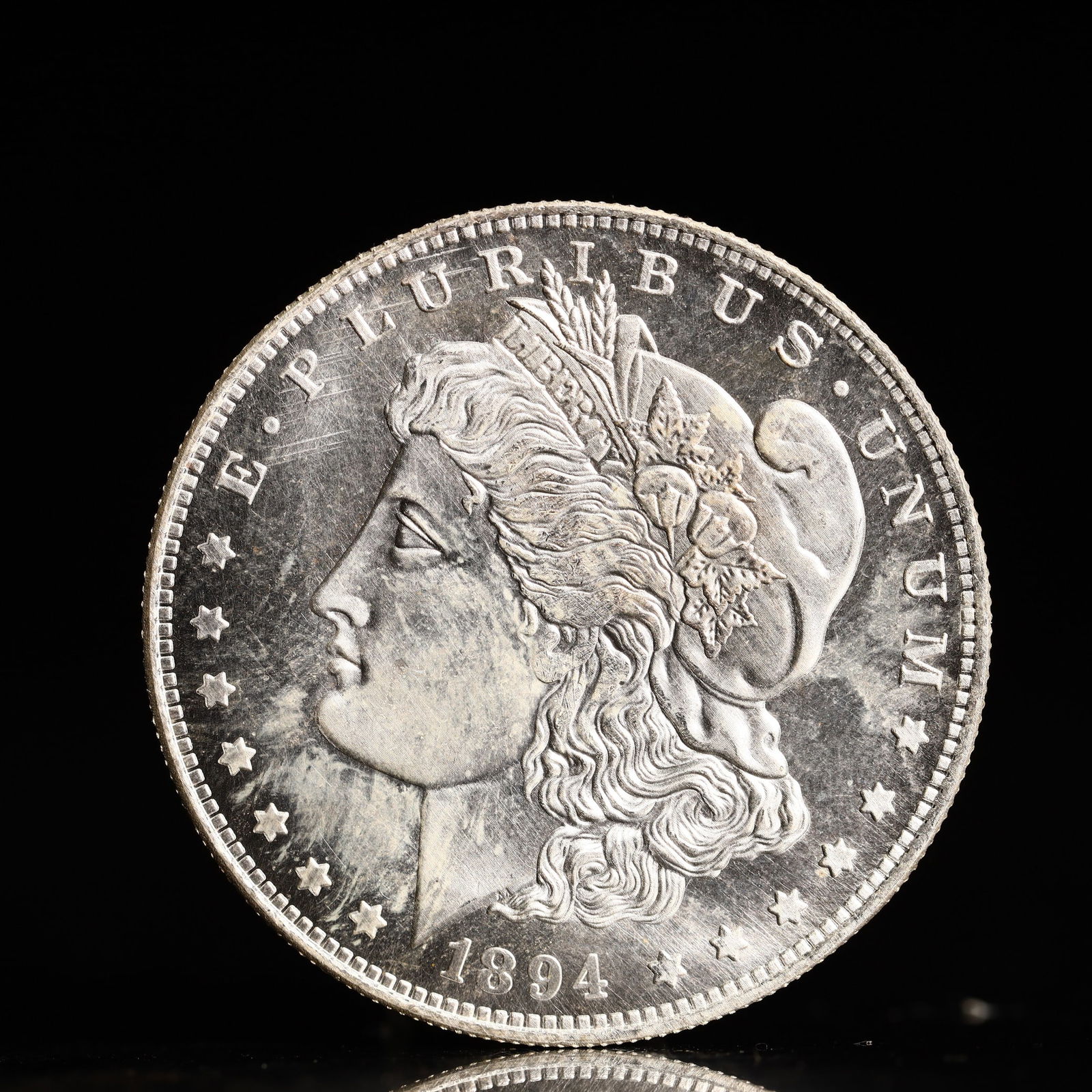 USA Morgan Dollar 1894 Coin: Obv: profile bust with date below and E PLURIBUS UNUM legend and stars around. Rev: eagle with In God we trust above within wreath with UNITED STATES OF AMERICA ONE DOLLAR legend. IN GOD WE TRUST /