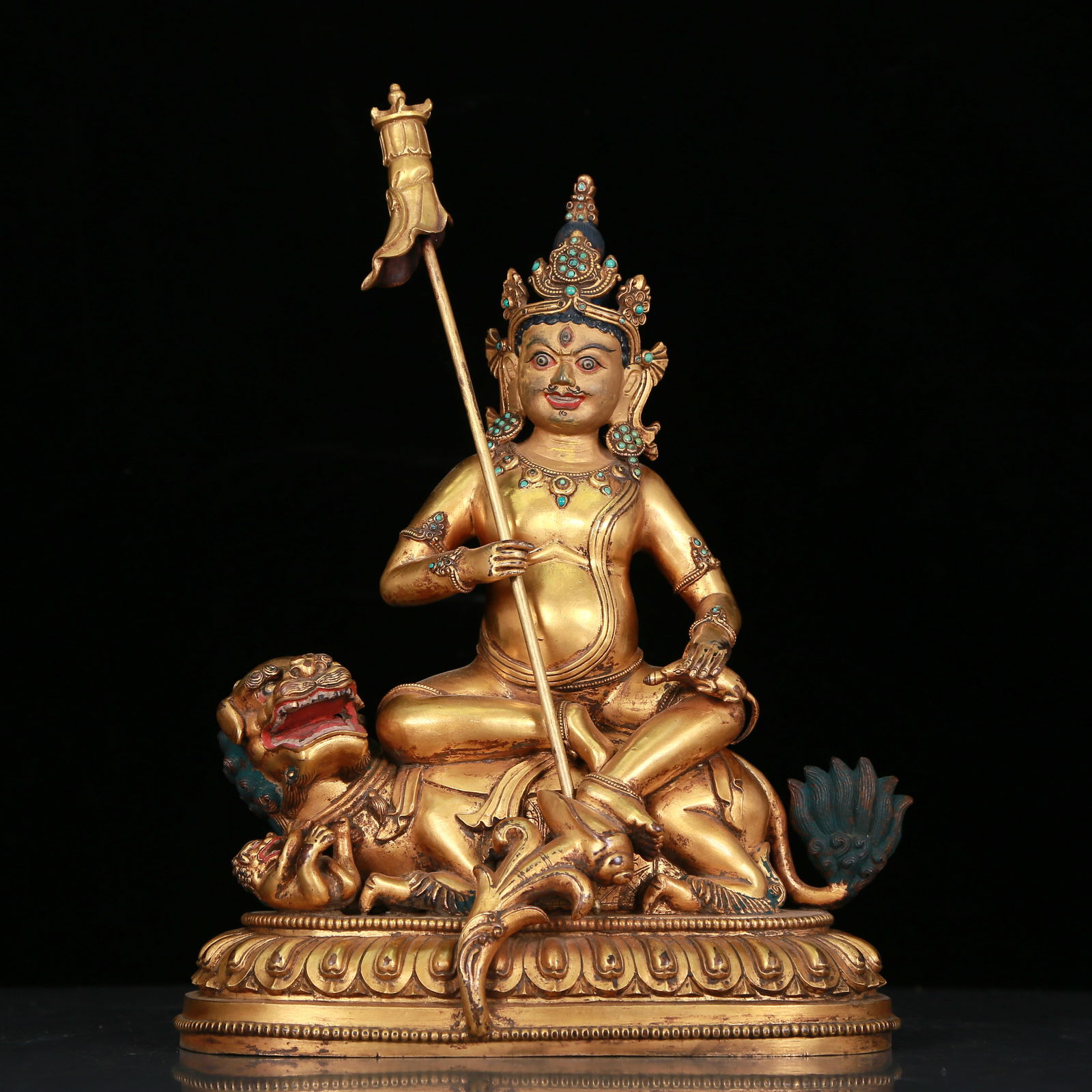 A Fabulous Gilt-Bronze Turquoise-Inlaid Figure Of Vaishravana: A Fabulous Gilt-Bronze Turquoise-Inlaid Figure Of Vaishravana. Seated on a recumbent mythical beast, body adorned with jewelry ornaments, topknot surmounted by a splendid diadem, and holds a holy weap