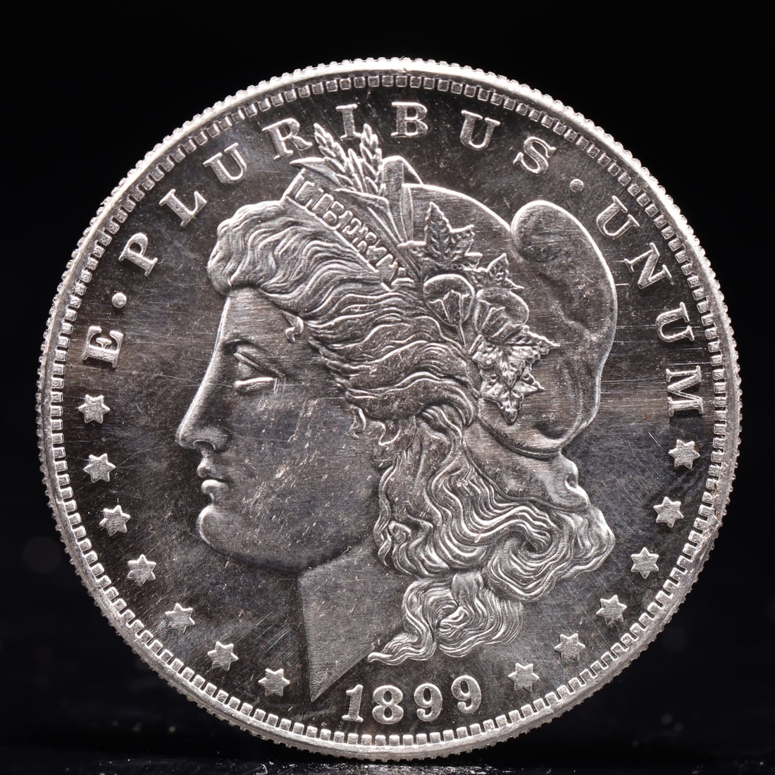 USA Morgan Dollar 1899 Coin: Obv: profile bust with date below and E PLURIBUS UNUM legend and stars around. Rev: eagle with In God we trust above within wreath with UNITED STATES OF AMERICA ONE DOLLAR legend. IN GOD WE TRUST /