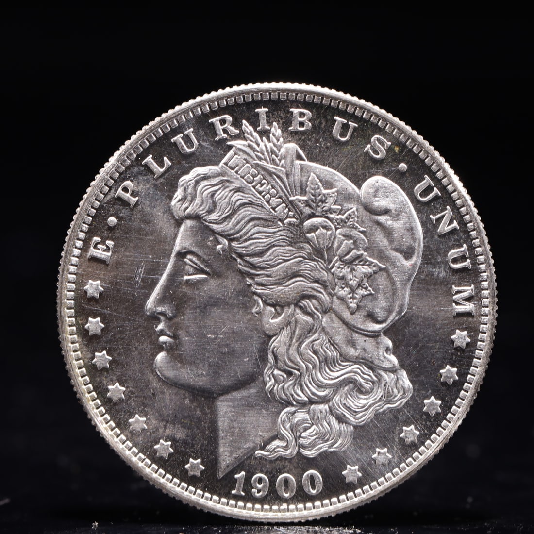 USA Morgan Dollar 1900 Coin: Obv: profile bust with date below and E PLURIBUS UNUM legend and stars around. Rev: eagle with In God we trust above within wreath with UNITED STATES OF AMERICA ONE DOLLAR legend. IN GOD WE TRUST /
