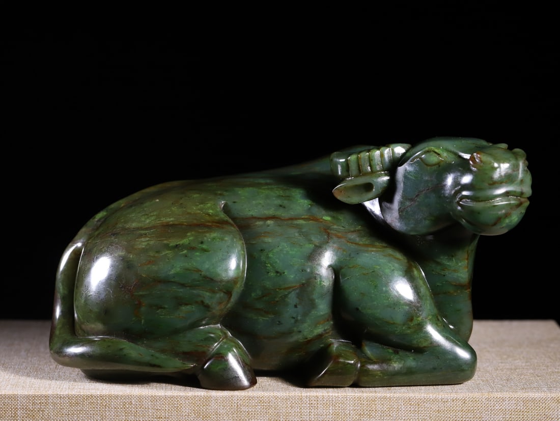 A Exquisite Hotan Jasper Buffalo Ornament: A Exquisite Hotan Jasper Buffalo Ornament,Qing Dynasty, China,Size:8.1inx3.5inx4in,Weight:2983g 和田碧玉牛摆件,中国清代