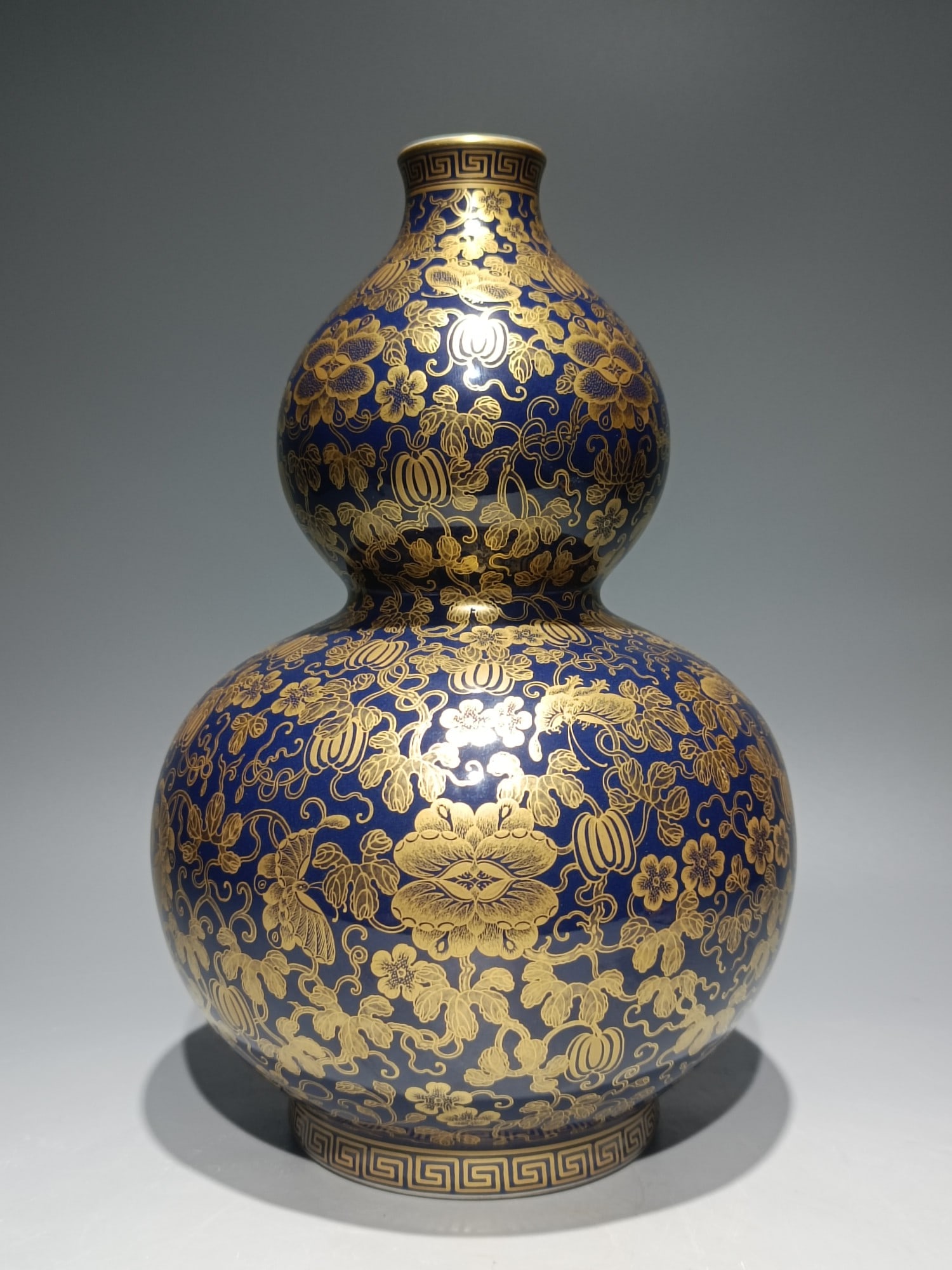 An Exquisite Ji Blue Glazed Painted Gold Flower and Butterfly Pattern Gourd-Shaped Vase: An Exquisite Ji Blue Glazed Painted Gold Flower and Butterfly Pattern Gourd-Shaped Vase,Qing Dynasty,China,Qianlong Six-character Mark,Size:11.6inx7.5in 霁蓝釉描金花