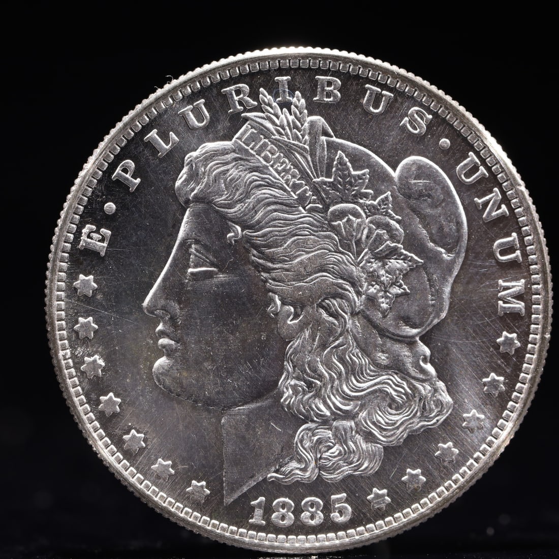 USA Morgan Dollar 1885 Coin: Obv: profile bust with date below and E PLURIBUS UNUM legend and stars around. Rev: eagle with In God we trust above within wreath with UNITED STATES OF AMERICA ONE DOLLAR legend. IN GOD WE TRUST / LI