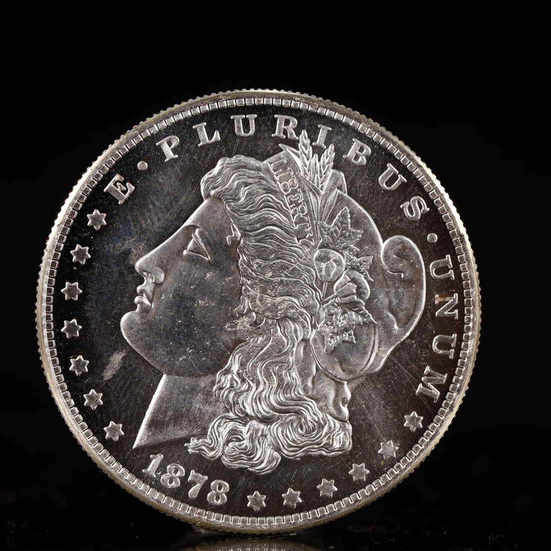 USA Morgan Dollar 1878 Coin: Obv: profile bust with date below and E PLURIBUS UNUM legend and stars around. Rev: eagle with In God we trust above within wreath with UNITED STATES OF AMERICA ONE DOLLAR legend. IN GOD WE TRUST / LI