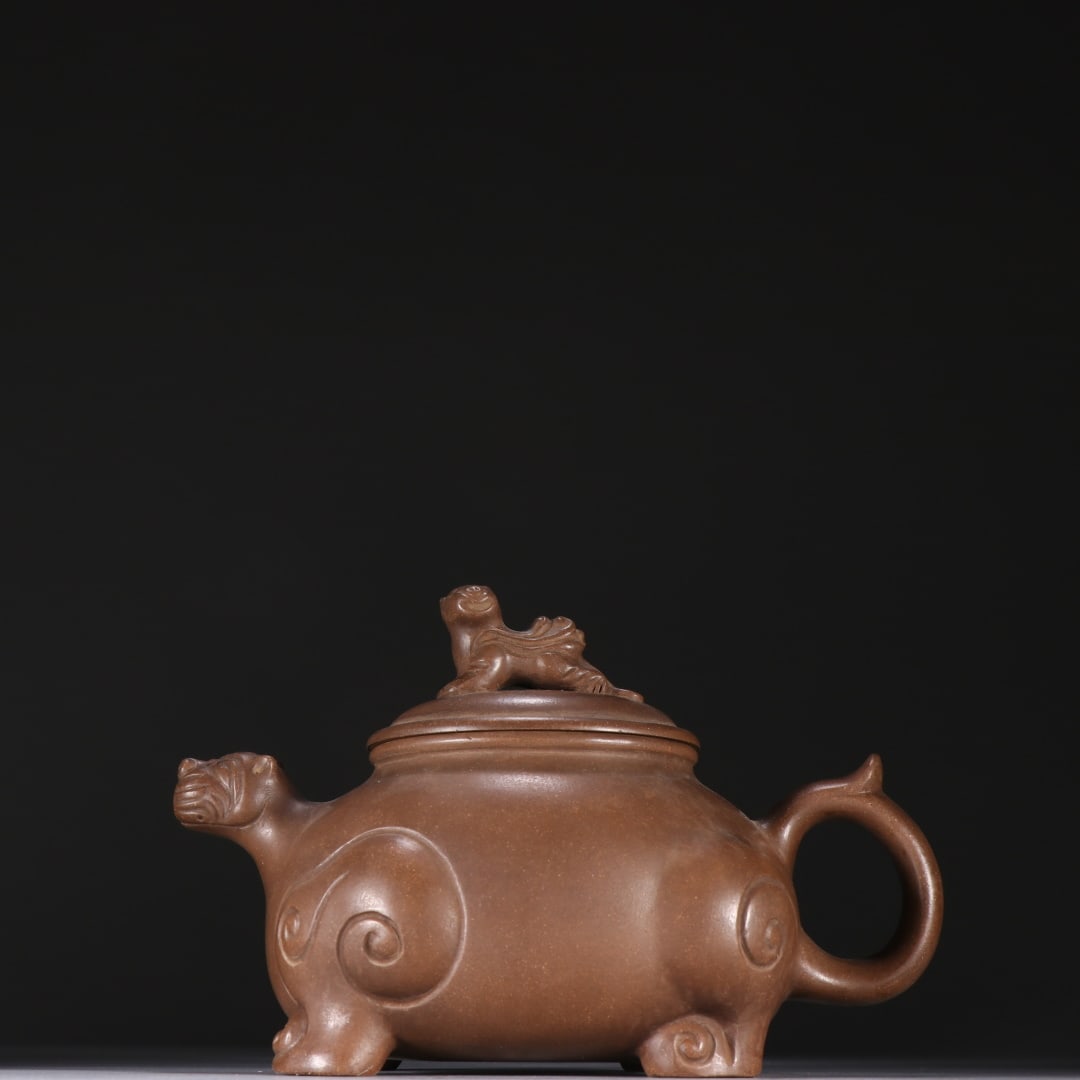 An Exquisite Purple Sands Auspicious Beast-Shaped Teapot: An Exquisite Purple Sands Auspicious Beast-Shaped Teapot Qing Dynasty, China Size:4.3inx6.5in紫砂瑞兽形壶 中国清代 Size:11cmx16.5cm