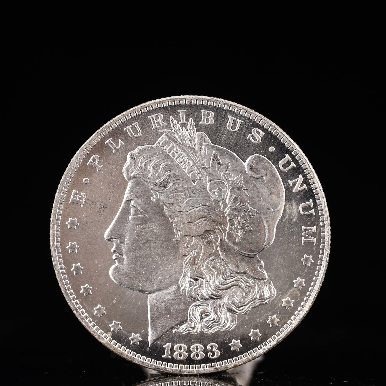 USA Morgan Dollar 1883 Coin: Obv: profile bust with date below and E PLURIBUS UNUM legend and stars around. Rev: eagle with In God we trust above within wreath with UNITED STATES OF AMERICA ONE DOLLAR legend. IN GOD WE TRUST / LI