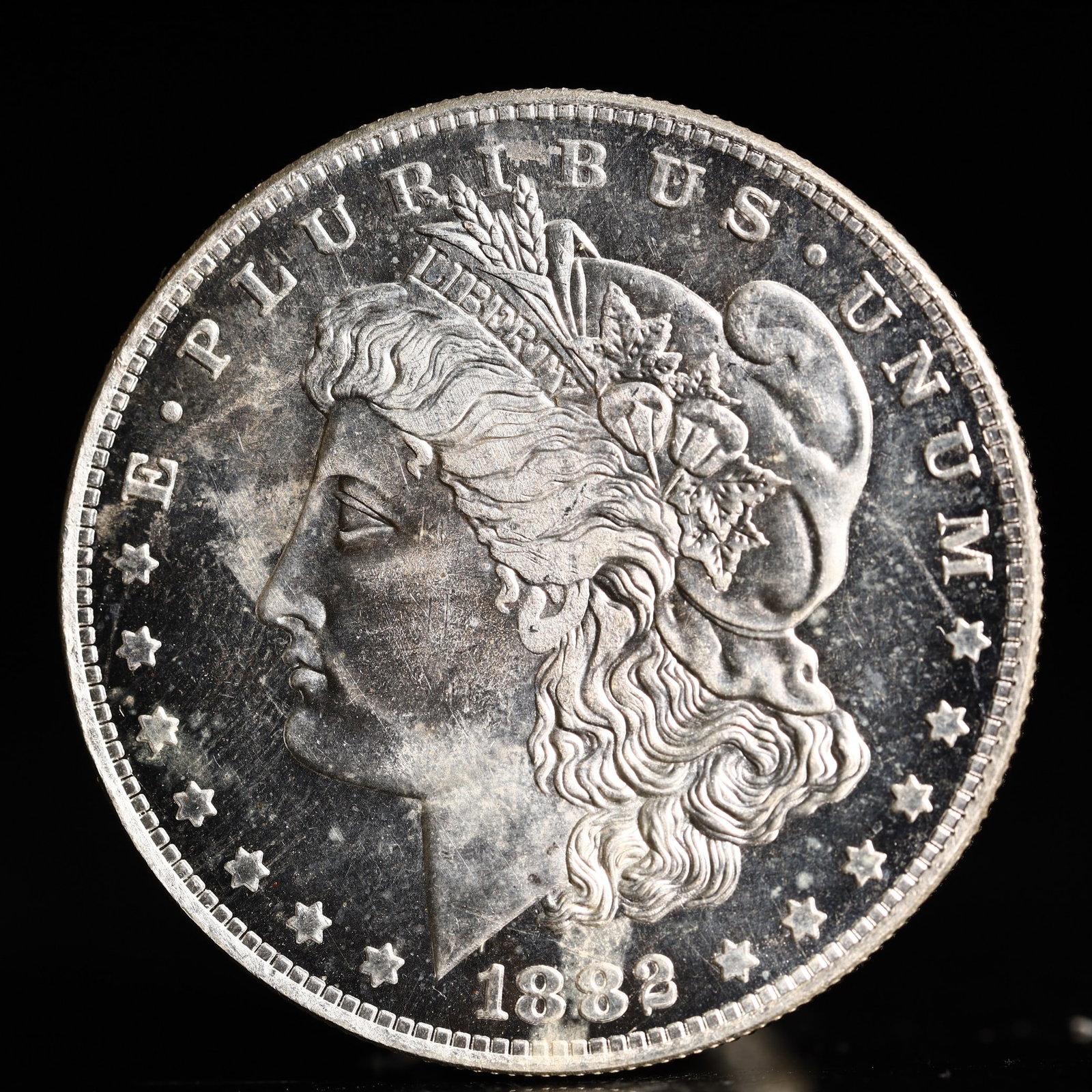 USA Morgan Dollar 1882 Coin: Obv: profile bust with date below and E PLURIBUS UNUM legend and stars around. Rev: eagle with In God we trust above within wreath with UNITED STATES OF AMERICA ONE DOLLAR legend. IN GOD WE TRUST / LI