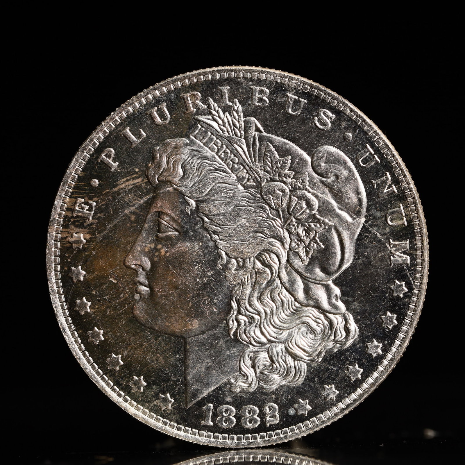 USA Morgan Dollar 1882 Coin: Obv: profile bust with date below and E PLURIBUS UNUM legend and stars around. Rev: eagle with In God we trust above within wreath with UNITED STATES OF AMERICA ONE DOLLAR legend. IN GOD WE TRUST / LI