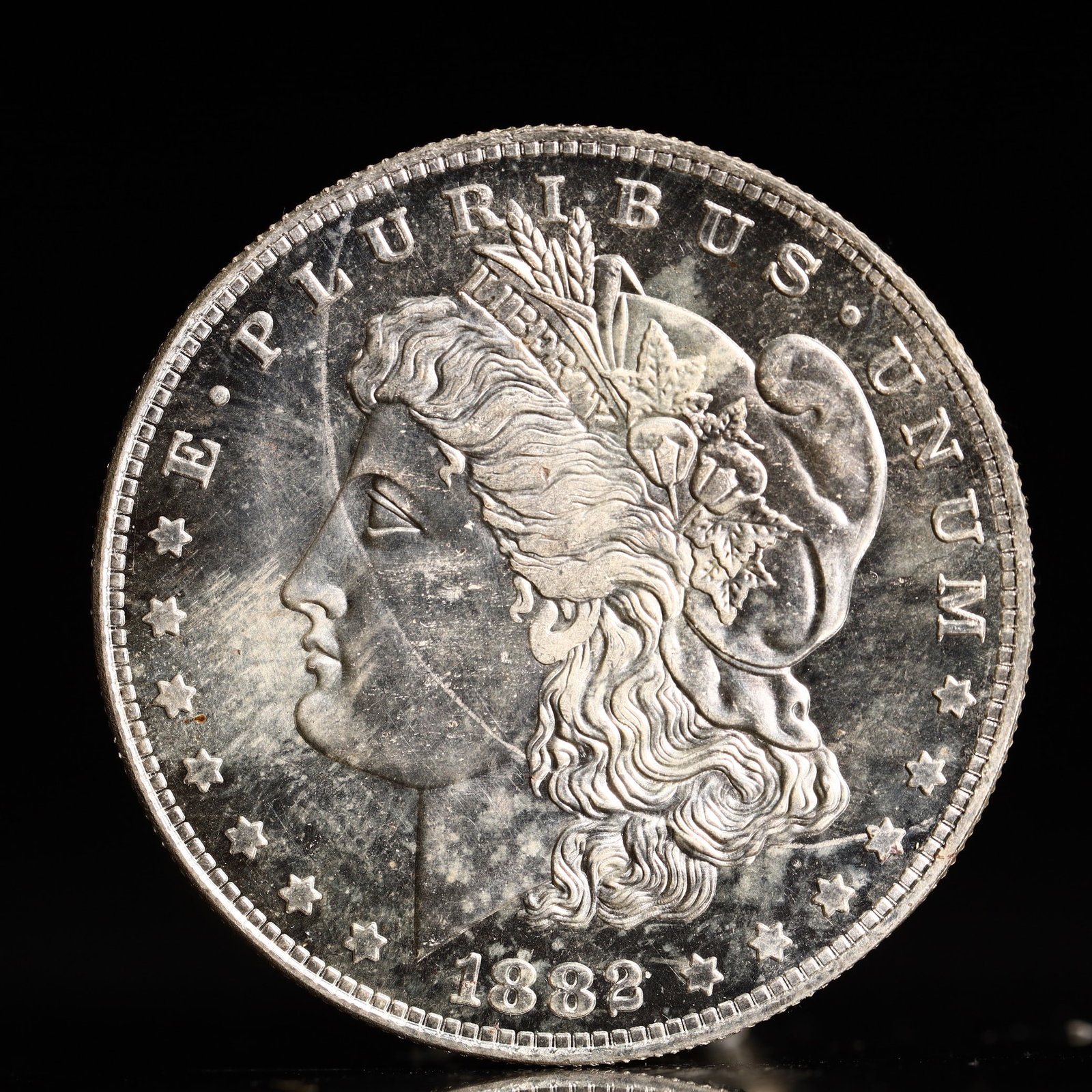 USA Morgan Dollar 1882 Coin: Obv: profile bust with date below and E PLURIBUS UNUM legend and stars around. Rev: eagle with In God we trust above within wreath with UNITED STATES OF AMERICA ONE DOLLAR legend. IN GOD WE TRUST / LI