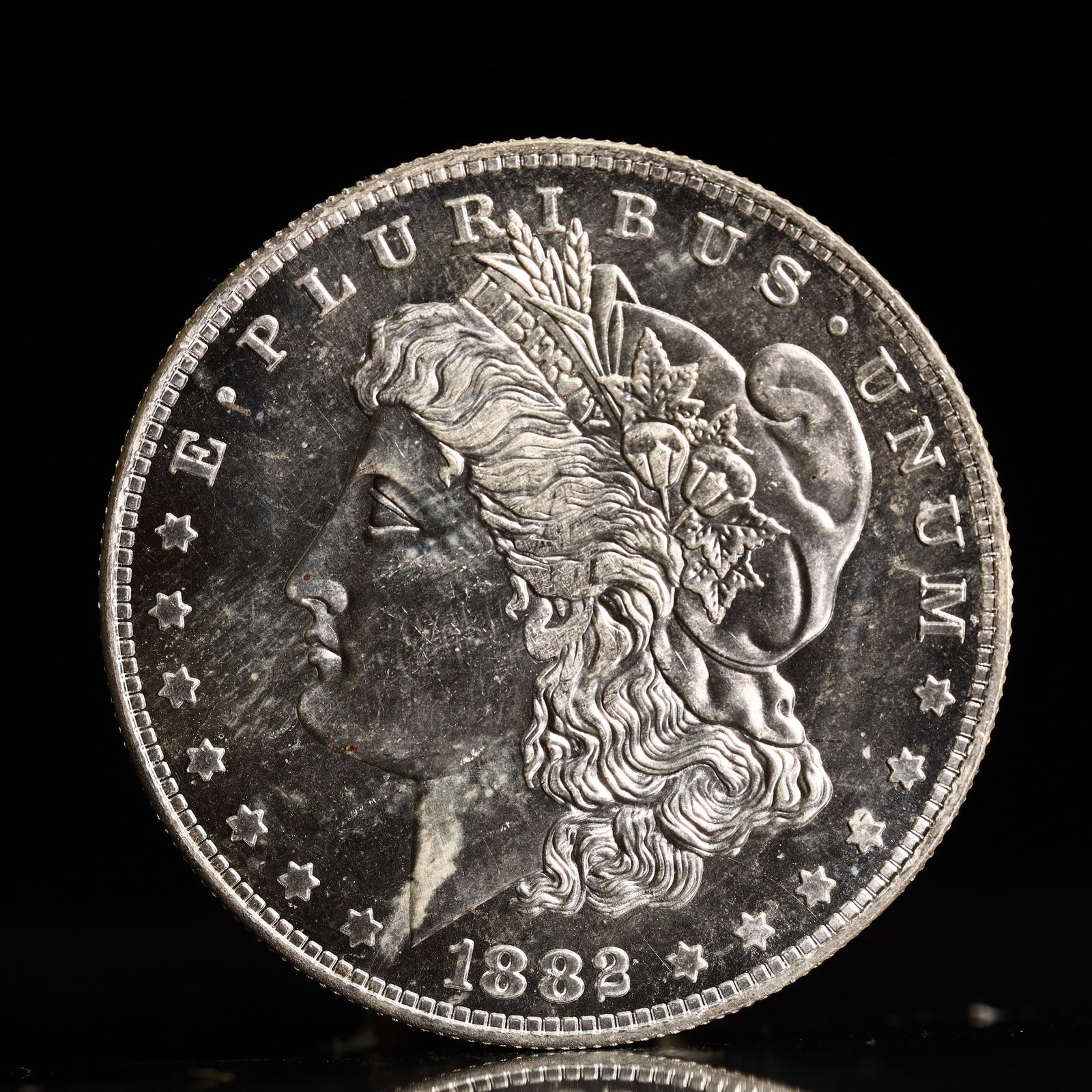 USA Morgan Dollar 1882 Coin: Obv: profile bust with date below and E PLURIBUS UNUM legend and stars around. Rev: eagle with In God we trust above within wreath with UNITED STATES OF AMERICA ONE DOLLAR legend. IN GOD WE TRUST / LI
