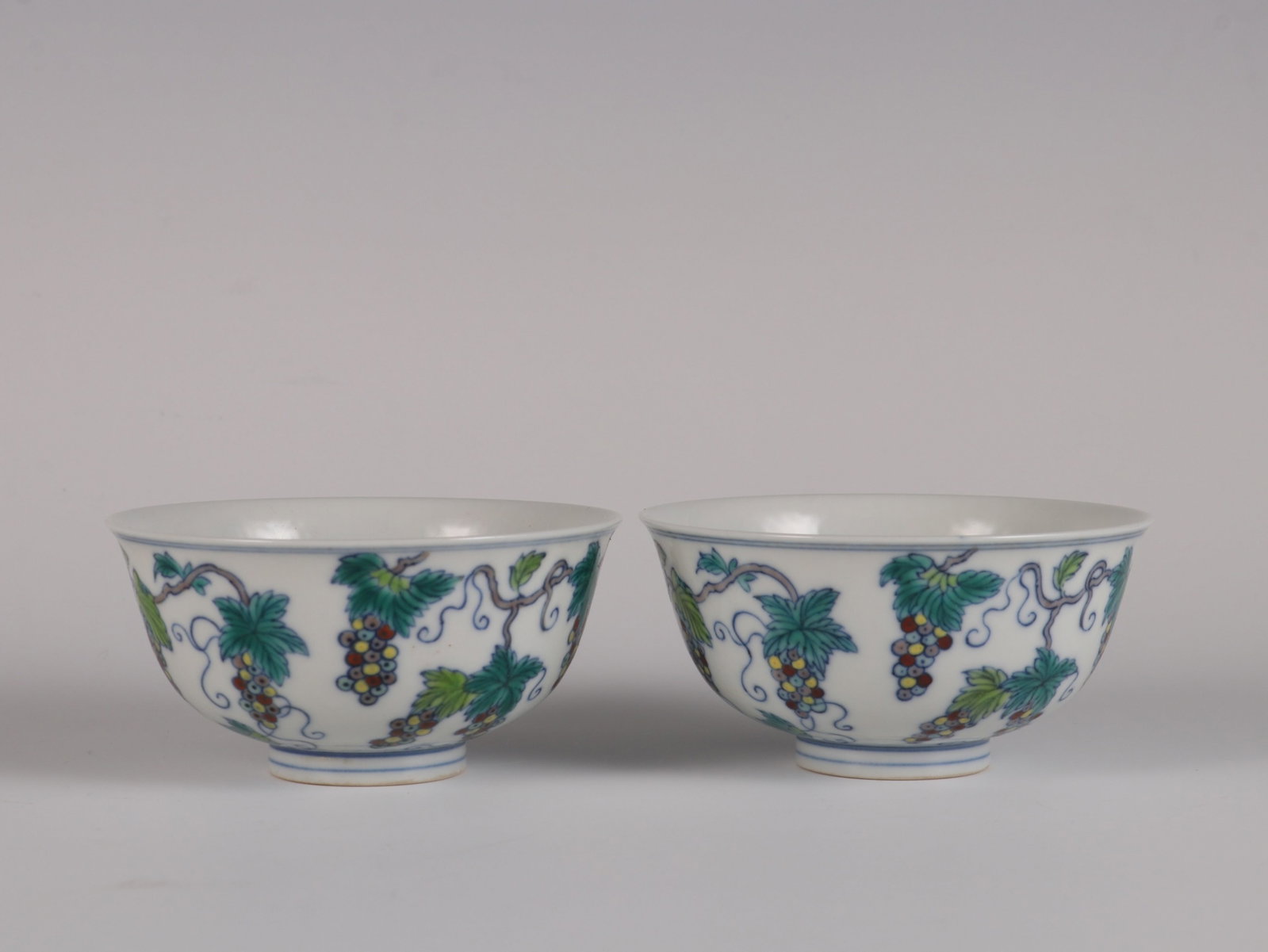 A Pair of Exquisite Doucai Melon and Fruit Pattern Cups: A Pair of Exquisite Doucai Melon and Fruit Pattern Cups,Qing Dynasty,China,Yongzheng Six-character Mark,Size:2inx3.7in 一对斗彩葡萄纹杯子,中