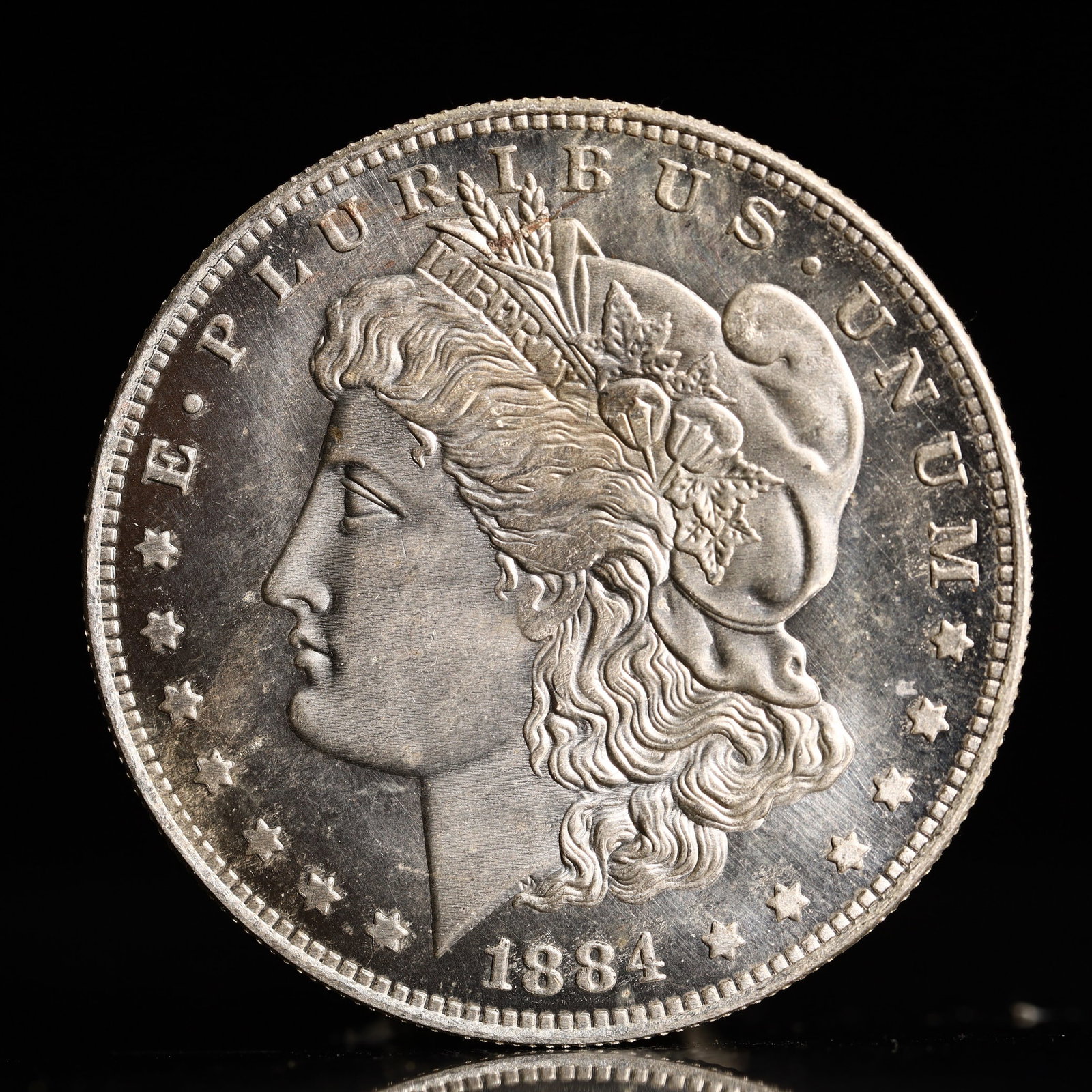 USA Morgan Dollar 1884 Coin: Obv: profile bust with date below and E PLURIBUS UNUM legend and stars around. Rev: eagle with In God we trust above within wreath with UNITED STATES OF AMERICA ONE DOLLAR legend. IN GOD WE TRUST /