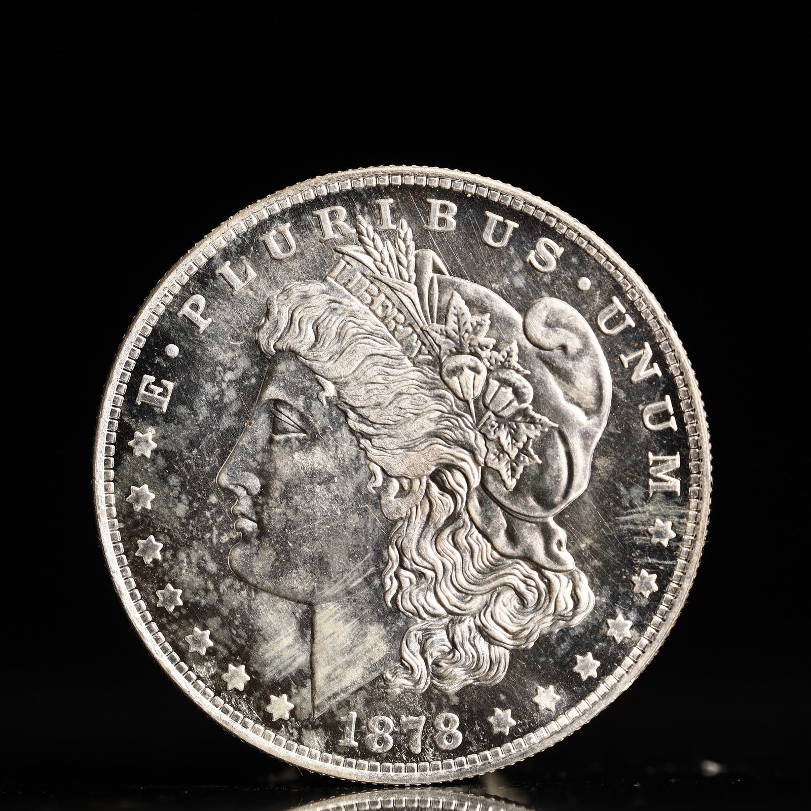USA Morgan Dollar 1878 Coin: Obv: profile bust with date below and E PLURIBUS UNUM legend and stars around. Rev: eagle with In God we trust above within wreath with UNITED STATES OF AMERICA ONE DOLLAR legend. IN GOD WE TRUST / LI