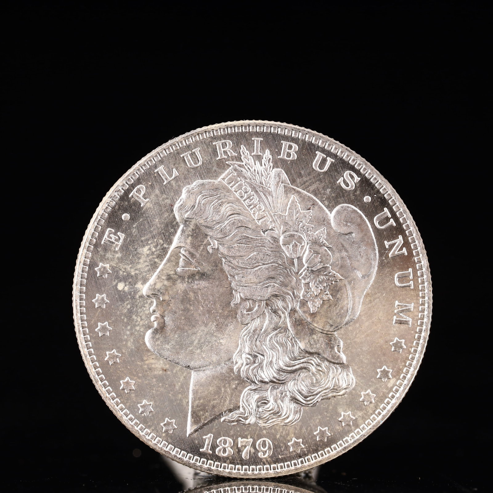 USA Morgan Dollar 1879 Coin: Obv: profile bust with date below and E PLURIBUS UNUM legend and stars around. Rev: eagle with In God we trust above within wreath with UNITED STATES OF AMERICA ONE DOLLAR legend. IN GOD WE TRUST / LI