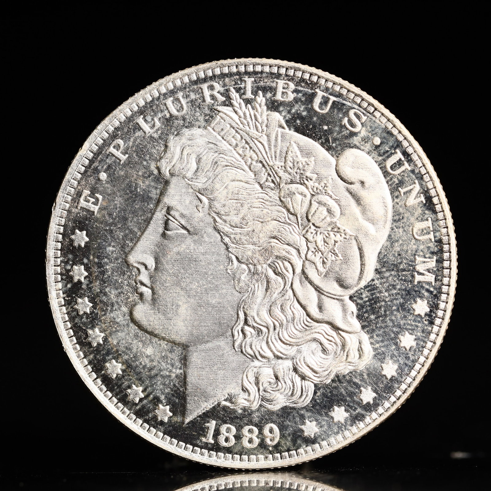 USA Morgan Dollar 1889 Coin: Obv: profile bust with date below and E PLURIBUS UNUM legend and stars around. Rev: eagle with In God we trust above within wreath with UNITED STATES OF AMERICA ONE DOLLAR legend. IN GOD WE TRUST / LI