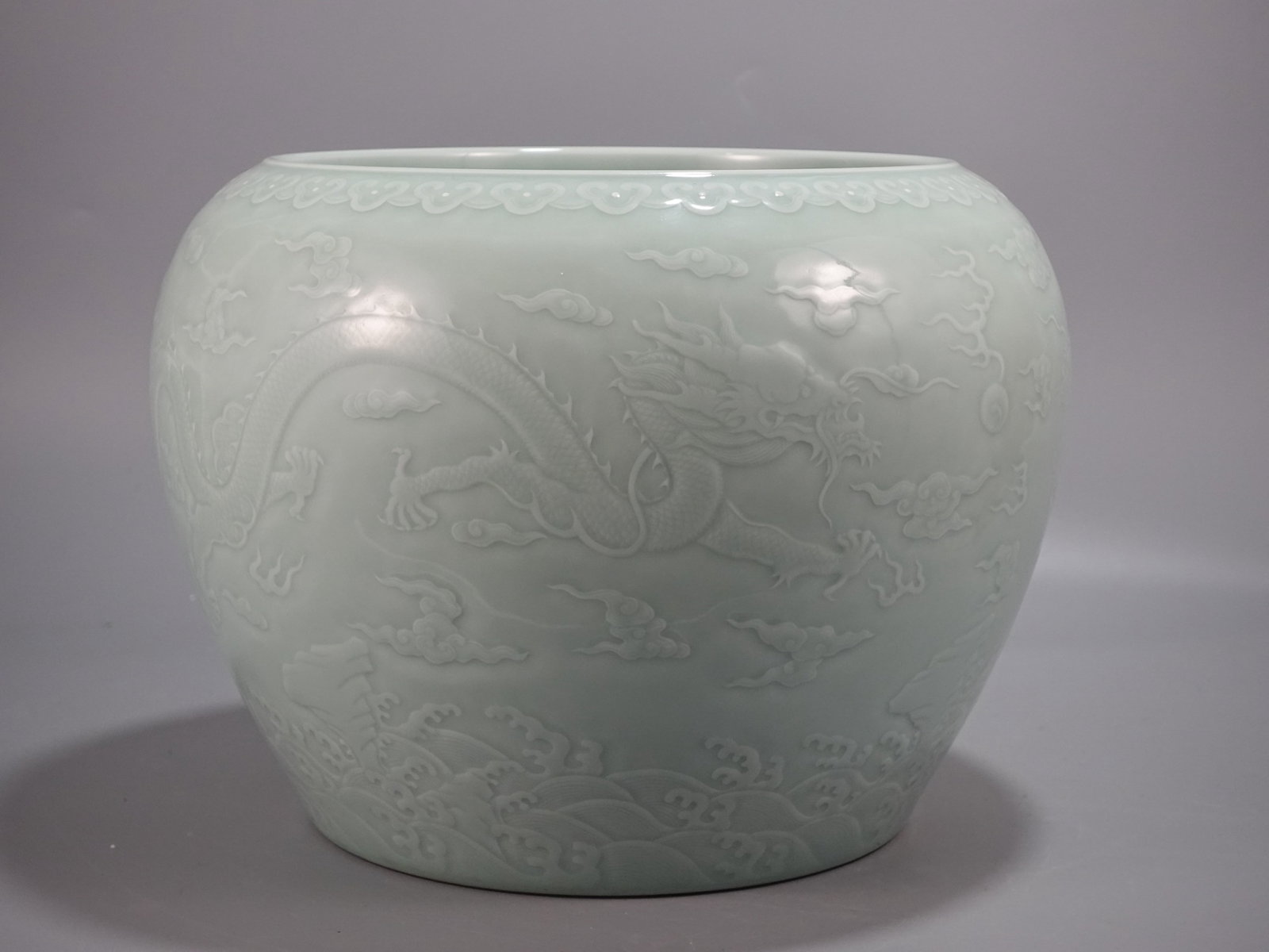 A Rare Celadon Glazed Auspicious Cloud and Dragon Pattern Vat: A Rare Celadon Glazed Auspicious Cloud and Dragon Pattern Vat,Qing Dynasty,China,Qianlong Six-character Mark,Size:10.6inx13.6in 粉青釉祥云龙纹缸,中