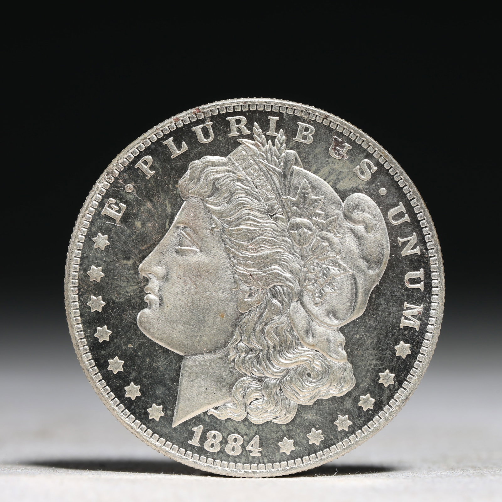 USA Morgan Dollar 1884 Coin: Obv: profile bust with date below and E PLURIBUS UNUM legend and stars around. Rev: eagle with In God we trust above within wreath with UNITED STATES OF AMERICA ONE DOLLAR legend. IN GOD WE TRUST / LI