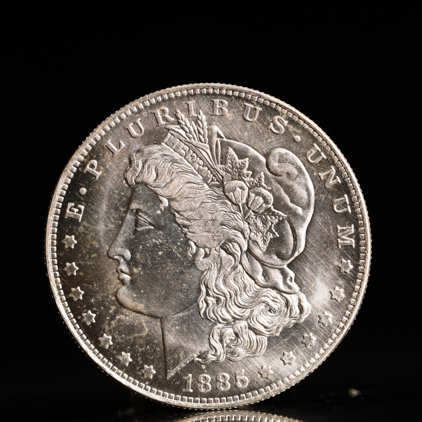 USA Morgan Dollar 1885 Coin: Obv: profile bust with date below and E PLURIBUS UNUM legend and stars around. Rev: eagle with In God we trust above within wreath with UNITED STATES OF AMERICA ONE DOLLAR legend. IN GOD WE TRUST / LI