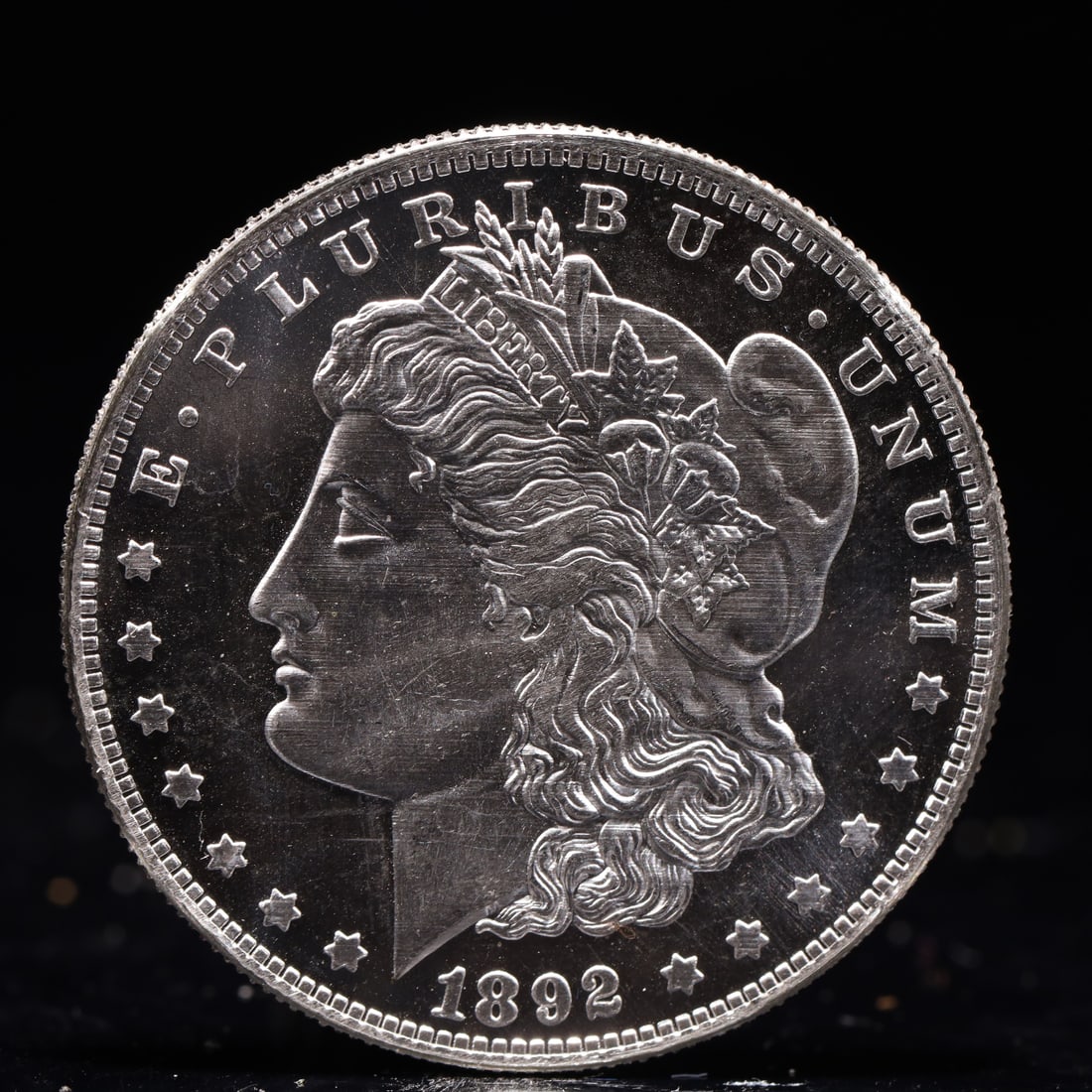 USA Morgan Dollar 1892 Coin: Obv: profile bust with date below and E PLURIBUS UNUM legend and stars around. Rev: eagle with In God we trust above within wreath with UNITED STATES OF AMERICA ONE DOLLAR legend. IN GOD WE TRUST / LI