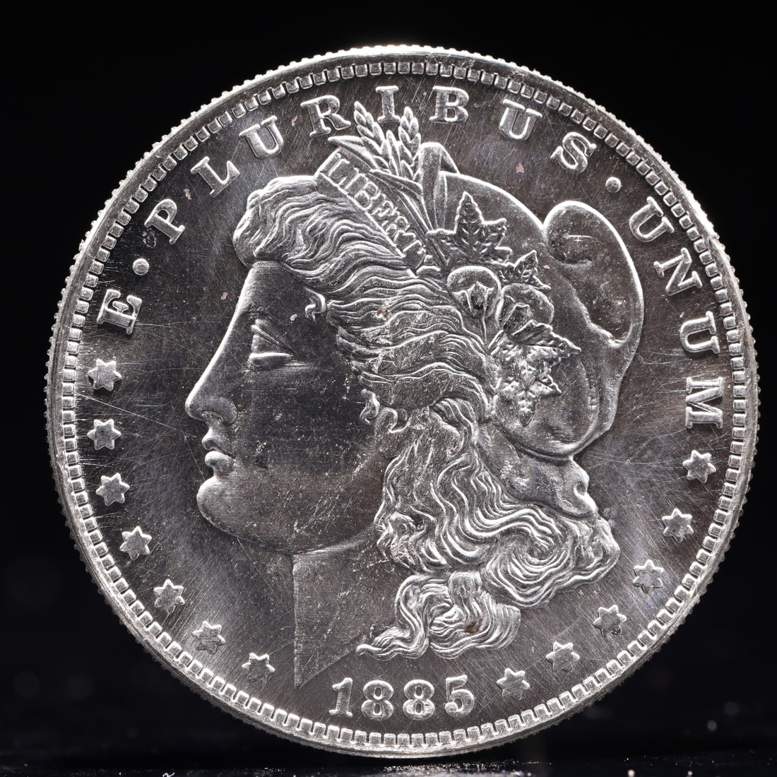USA Morgan Dollar 1885 Coin: Obv: profile bust with date below and E PLURIBUS UNUM legend and stars around. Rev: eagle with In God we trust above within wreath with UNITED STATES OF AMERICA ONE DOLLAR legend. IN GOD WE TRUST / LI