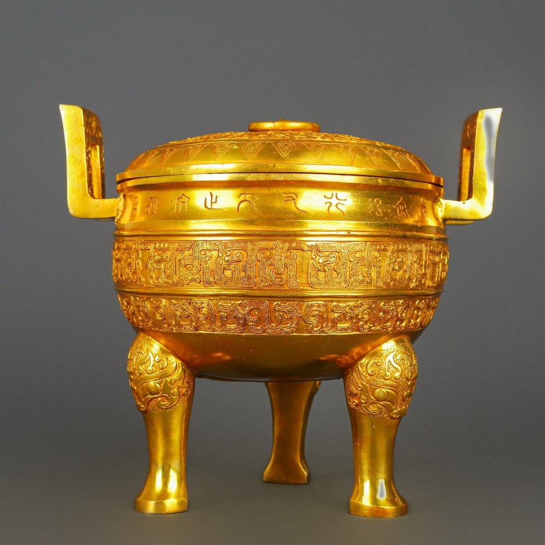 An Exquisite Gilt Bronze With Inscription Double-Ears and Tripod Censer: An Exquisite Gilt Bronze With Inscription Double-Ears and Tripod Censer Han Dynasty, China Size:13inx11.4in Weight:5500g铜鎏金圆盖鼎 中国汉代