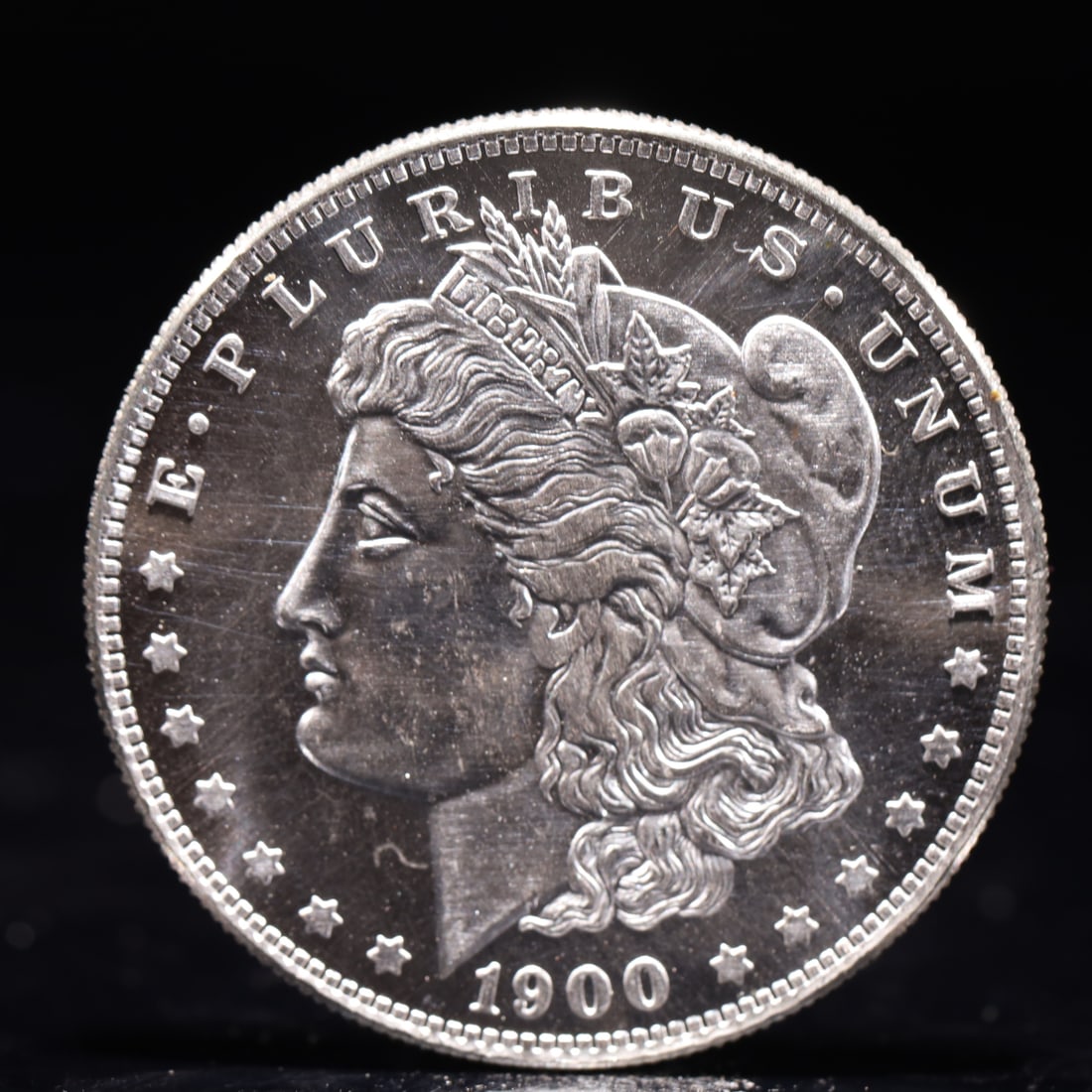 USA Morgan Dollar 1900 Coin: Obv: profile bust with date below and E PLURIBUS UNUM legend and stars around. Rev: eagle with In God we trust above within wreath with UNITED STATES OF AMERICA ONE DOLLAR legend. IN GOD WE TRUST / LI