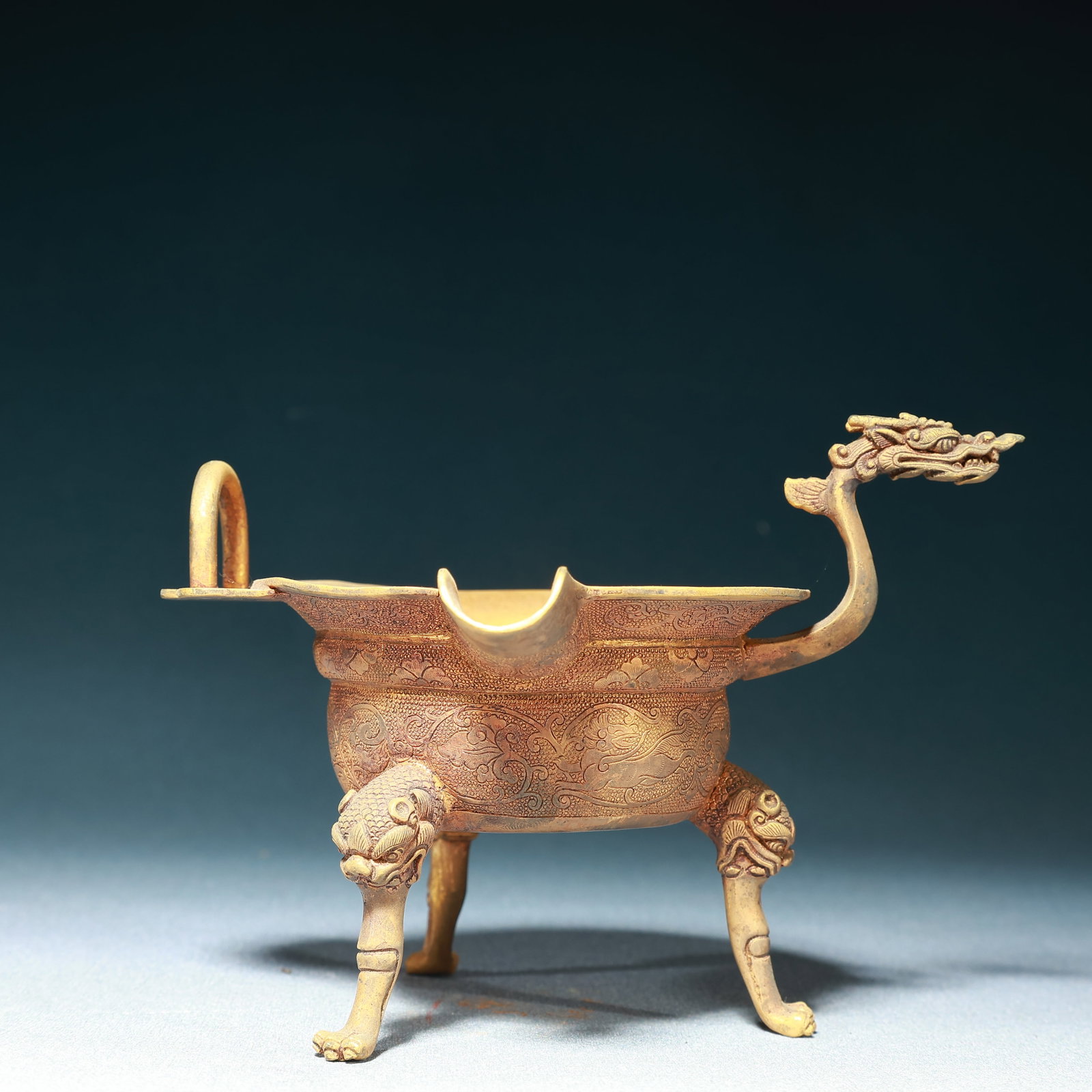 An Exquisite Gilt Bronze Lotus and Auspicious Beast Pattern Dragon-head Tripod Cup: An Exquisite Gilt Bronze Lotus and Auspicious Beast Pattern Dragon-head Tripod Cup,Qing Dynasty,China,Size:6.1inx4.9inx4.3in,Weight:300g 铜鎏金缠枝莲瑞兽