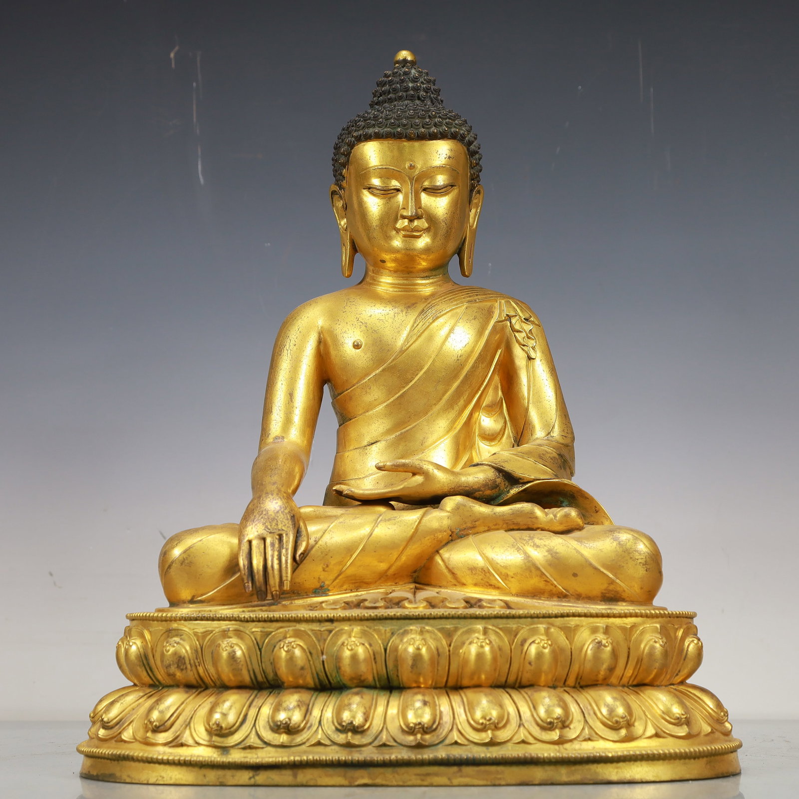 A Fabulous Gilt-Bronze Figure Of Buddha Shakyamuni: A Fabulous Gilt-Bronze Figure Of Buddha Shakyamuni. Superbly and sensitively sculpted in the form of a seated Buddha Shakyamuni,with well-defined arched eyebrows juxtaposed with the prominent nose abo