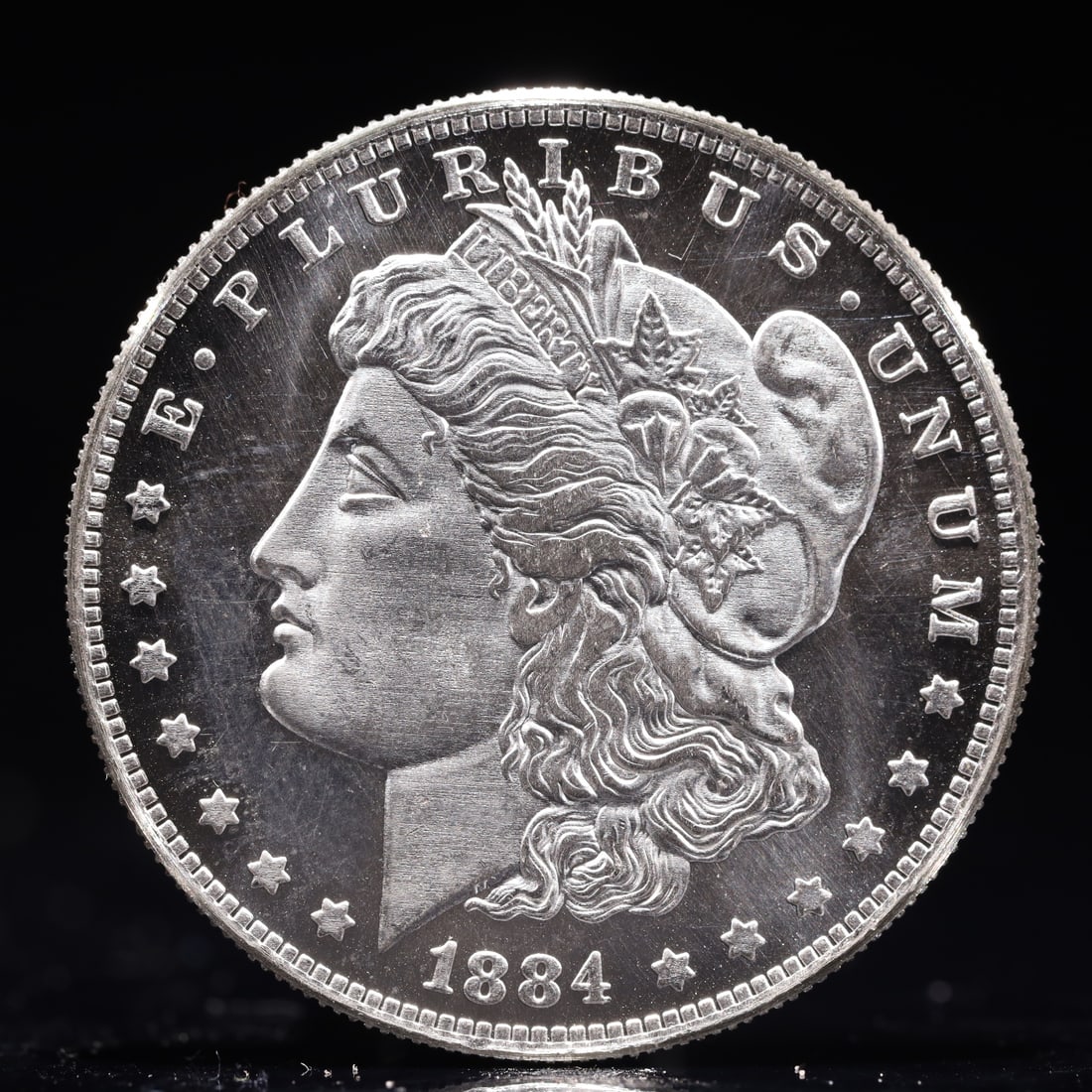 USA Morgan Dollar 1884 Coin: Obv: profile bust with date below and E PLURIBUS UNUM legend and stars around. Rev: eagle with In God we trust above within wreath with UNITED STATES OF AMERICA ONE DOLLAR legend. IN GOD WE TRUST / LI