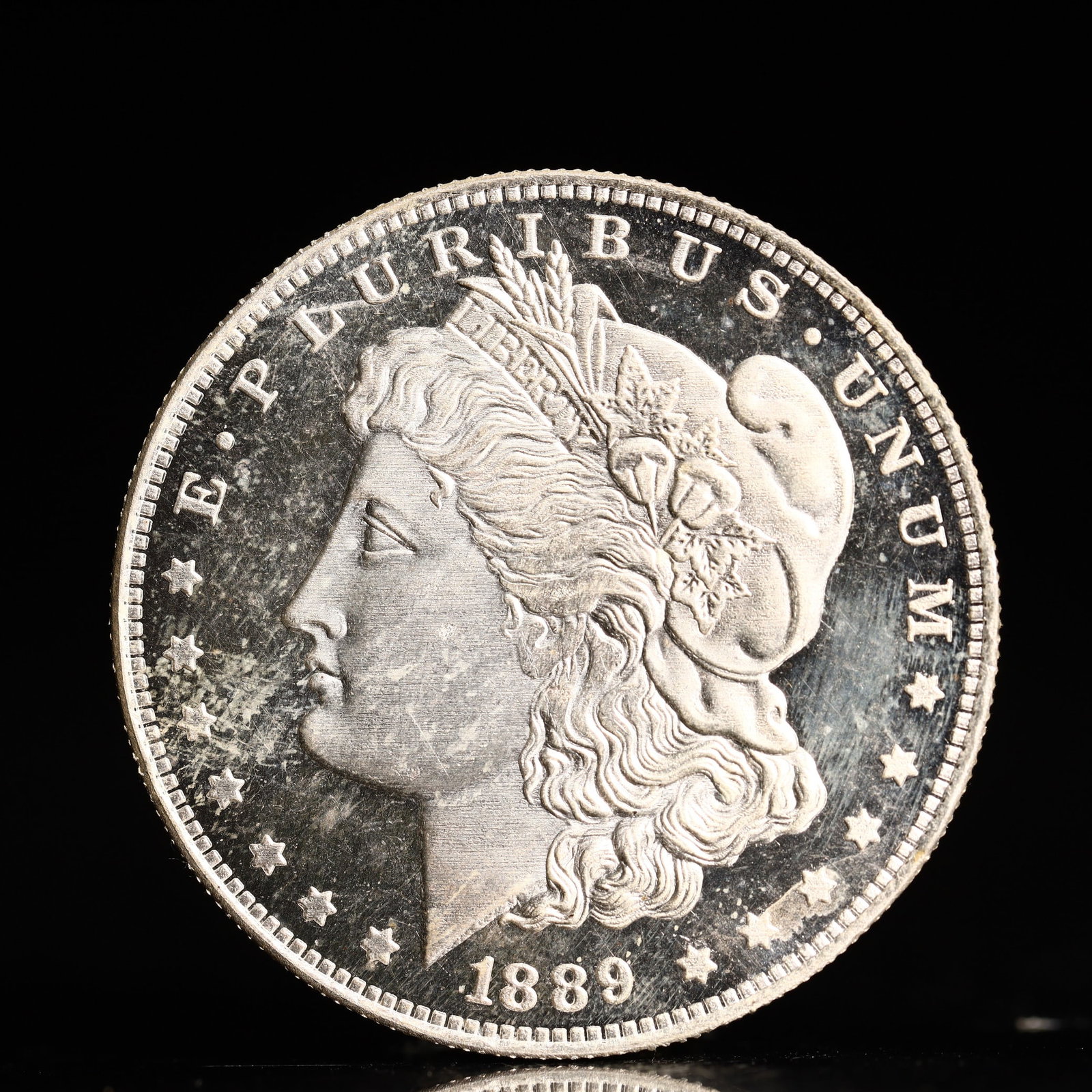 USA Morgan Dollar 1889 Coin: Obv: profile bust with date below and E PLURIBUS UNUM legend and stars around. Rev: eagle with In God we trust above within wreath with UNITED STATES OF AMERICA ONE DOLLAR legend. IN GOD WE TRUST /