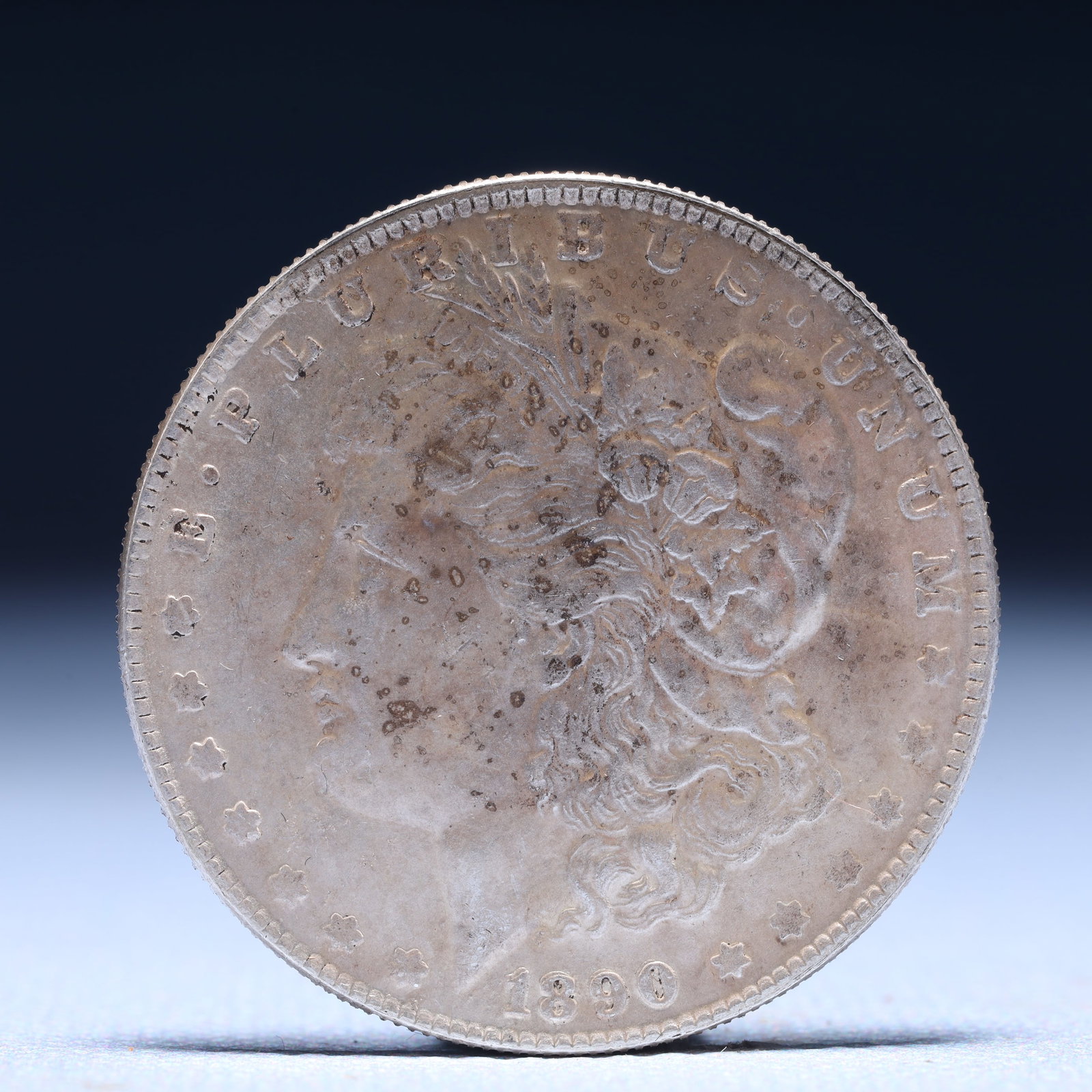 USA Morgan Dollar 1890 Coin: Obv: profile bust with date below and E PLURIBUS UNUM legend and stars around. Rev: eagle with In God we trust above within wreath with UNITED STATES OF AMERICA ONE DOLLAR legend. IN GOD WE TRUST /