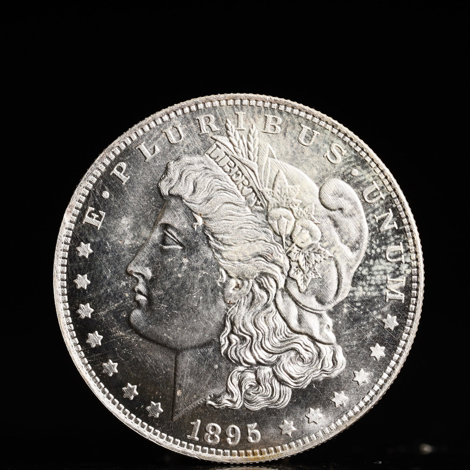 USA Morgan Dollar 1895 Coin: Obv: profile bust with date below and E PLURIBUS UNUM legend and stars around. Rev: eagle with In God we trust above within wreath with UNITED STATES OF AMERICA ONE DOLLAR legend. IN GOD WE TRUST / LI