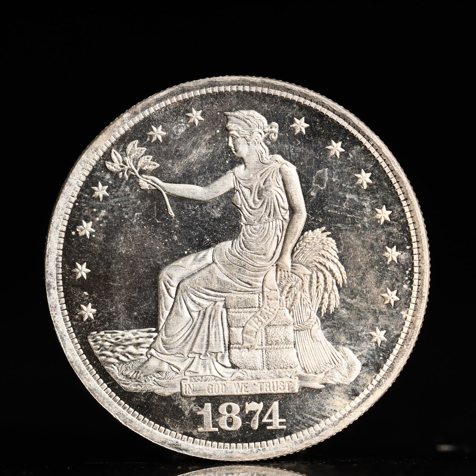 USA Trade Dollar 1874 Coin: American coin. Obverse: Liberty seated on a pedestal facing the sea to the left holding olive branches surrounded by 13 stars. IN GOD WE TRUST / LIBERTY / 1874. Reverse: An eagle holding branches with