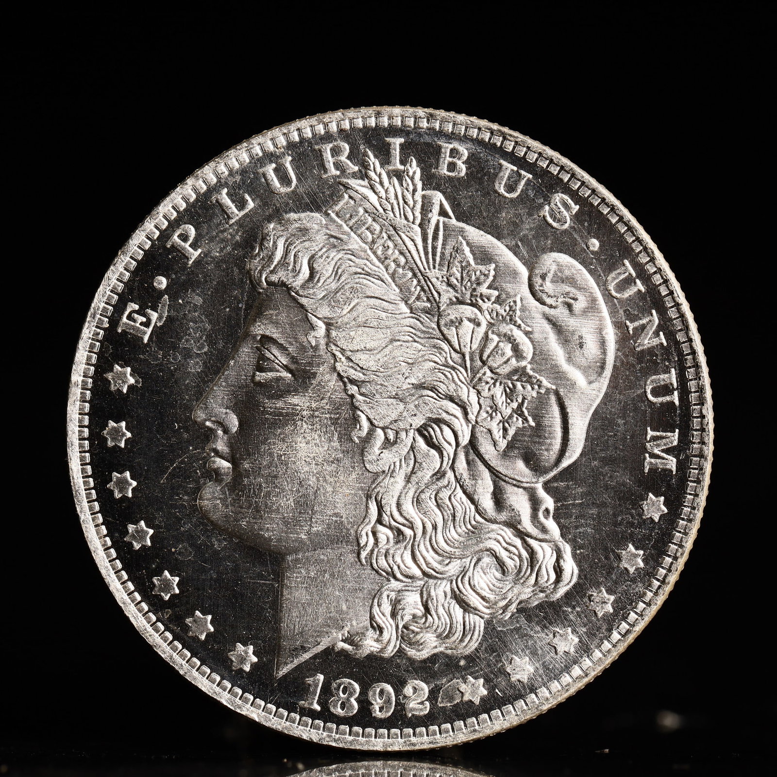 USA Morgan Dollar 1892 Coin: Obv: profile bust with date below and E PLURIBUS UNUM legend and stars around. Rev: eagle with In God we trust above within wreath with UNITED STATES OF AMERICA ONE DOLLAR legend. IN GOD WE TRUST / LI