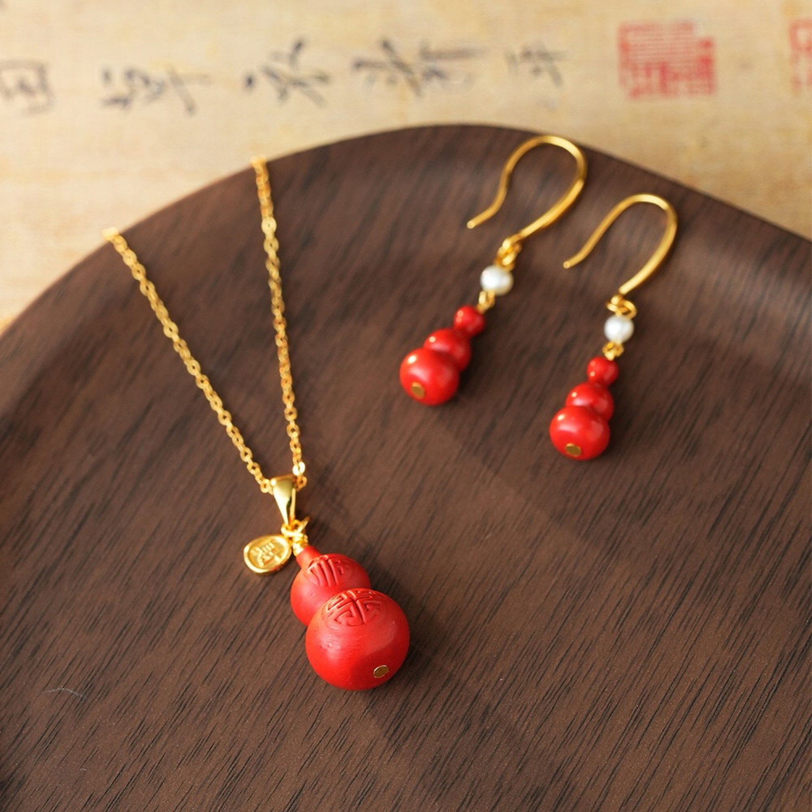 A Set of Fine Sterling Silver-Gold Plated Inlaid Cinnabar Gourd Jewelrys: A Set of Fine Sterling Silver-Gold Plated Inlaid Cinnabar Gourd Jewelrys,Size:(Earrings)14mmx7mmx39mm,(Pendant)20mmx12mm,Total Weight:7.37g 一套纯银镀金镶